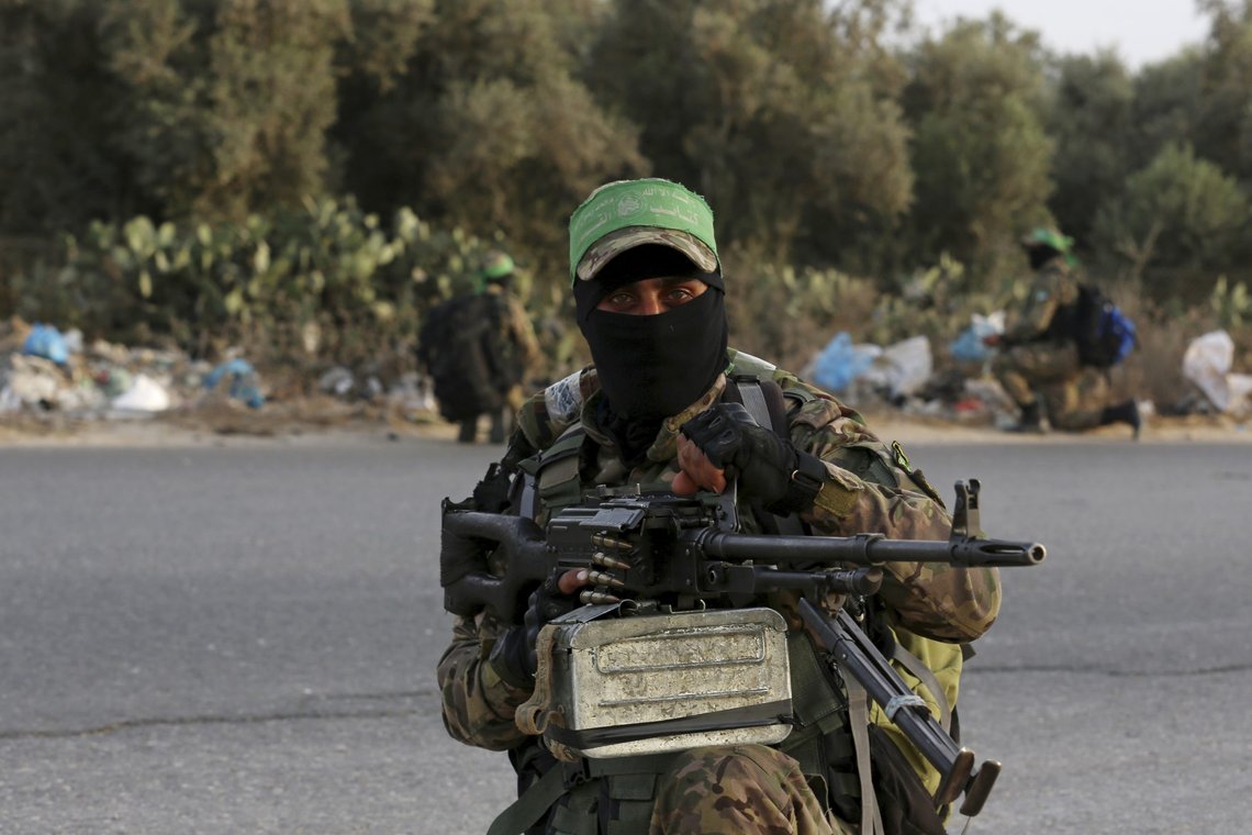 Masked militant from the Izzedine al-Qassam Brigades, a military wing of Hamas, takes position to secure his colleagues while marching along the main road of Nusseirat refugee camp, central Gaza Strip, Thursday, Oct. 28, 2021. Arabic on the headband reads, "No God but Allah and Muhammed is his messenger, al-Qassam Brigades." (AP Photo/Adel Hana) Masked militant from the Izzedine al-Qassam Brigades, a military wing of Hamas, takes position to secure his colleagues while marching along the main road of Nusseirat refugee camp, central Gaza Strip, Thursday, Oct. 28, 2021. Arabic on the headband reads, "No God but Allah and Muhammed is his messenger, al-Qassam Brigades." (AP Photo/Adel Hana)
