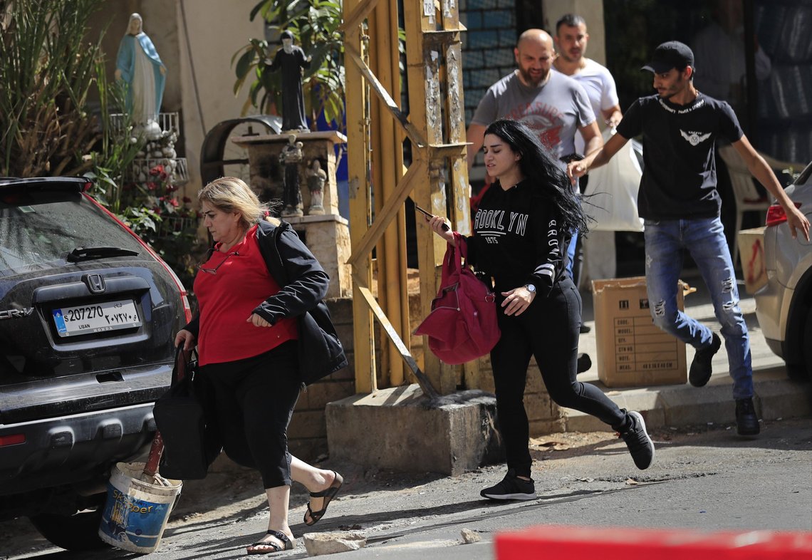 Lebanese Christians flee their houses amid sniper fire after deadly clashes erupted along a former 1975-90 civil war front-line between Muslim Shiite and Christian areas, in Ain el-Remaneh neighborhood, Beirut, Lebanon, Thursday, Oct. 14, 2021. Armed clashes broke out in Beirut Thursday during the protest against the lead judge investigating last year's massive blast in the city's port, as tensions over the domestic probe boiled over. (AP Photo/Hussein Malla) Lebanese Christians flee their houses amid sniper fire after deadly clashes erupted along a former 1975-90 civil war front-line between Muslim Shiite and Christian areas, in Ain el-Remaneh neighborhood, Beirut, Lebanon, Thursday, Oct. 14, 2021. Armed clashes broke out in Beirut Thursday during the protest against the lead judge investigating last year's massive blast in the city's port, as tensions over the domestic probe boiled over. (AP Photo/Hussein Malla)