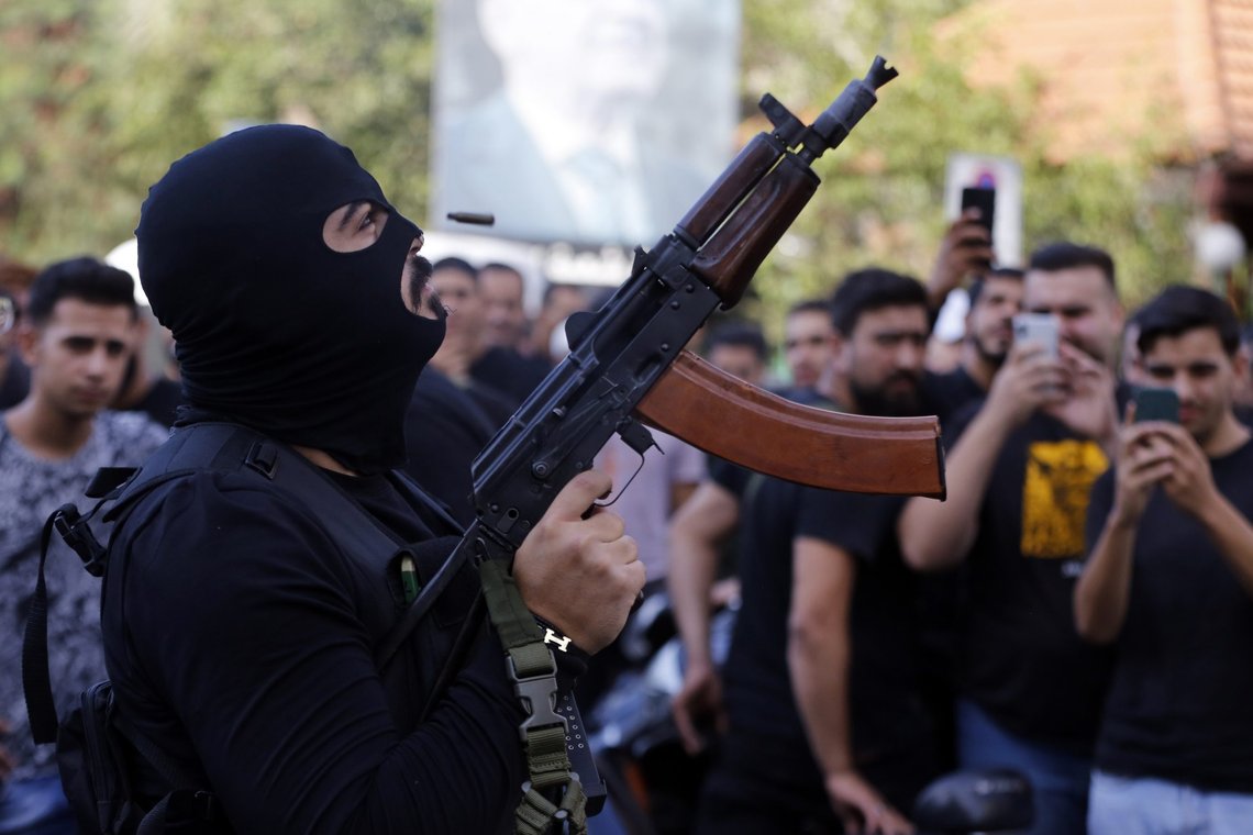 A man fires in the air during the funeral of three Hezbollah supporters who were killed during Thursday clashes, in the southern Beirut suburb of Dahiyeh, Lebanon, Friday, Oct. 15, 2021. The government called for a day of mourning following the armed clashes, in which gunmen used automatic weapons and rocket-propelled grenades on the streets of the capital, echoing the nation's darkest era of the 1975-90 civil war. (AP Photo/Bilal Hussein) A man fires in the air during the funeral of three Hezbollah supporters who were killed during Thursday clashes, in the southern Beirut suburb of Dahiyeh, Lebanon, Friday, Oct. 15, 2021. The government called for a day of mourning following the armed clashes, in which gunmen used automatic weapons and rocket-propelled grenades on the streets of the capital, echoing the nation's darkest era of the 1975-90 civil war. (AP Photo/Bilal Hussein)
