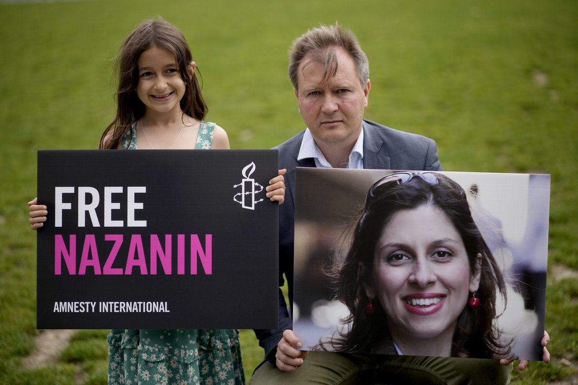 Richard Ratcliffe, the husband of imprisoned British-Iranian Nazanin Zaghari-Ratcliffe and their seven year old daughter Gabriella pose for the media backdropped by the scaffolded Houses of Parliament and the Elizabeth Tower, known as Big Ben, in Parliament Square, London, to mark the 2,000 days she has been detained in Iran, Thursday, Sept. 23, 2021. Zaghari-Ratcliffe was originally sentenced to five years in prison after being convicted of plotting the overthrow of Iran's government, a charge that she, her supporters and rights groups deny. While employed at the Thomson Reuters Foundation, the charitable arm of the news agency, she was taken into custody at the Tehran airport in April 2016 as she was returning home to Britain after visiting family. (AP Photo/Matt Dunham) Richard Ratcliffe, the husband of imprisoned British-Iranian Nazanin Zaghari-Ratcliffe and their seven year old daughter Gabriella pose for the media backdropped by the scaffolded Houses of Parliament and the Elizabeth Tower, known as Big Ben, in Parliament Square, London, to mark the 2,000 days she has been detained in Iran, Thursday, Sept. 23, 2021. Zaghari-Ratcliffe was originally sentenced to five years in prison after being convicted of plotting the overthrow of Iran's government, a charge that she, her supporters and rights groups deny. While employed at the Thomson Reuters Foundation, the charitable arm of the news agency, she was taken into custody at the Tehran airport in April 2016 as she was returning home to Britain after visiting family. (AP Photo/Matt Dunham)