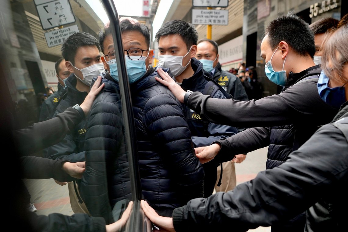 Editor of Stand News' Patrick Lam, center, is escorted by police officers into a van after they searched evidence at his office in Hong Kong, Wednesday, Dec. 29, 2021. Hong Kong police raided the office of the online news outlet on Wednesday after arresting several people for conspiracy to publish a seditious publication. (AP Photo/Vincent Yu) Editor of Stand News' Patrick Lam, center, is escorted by police officers into a van after they searched evidence at his office in Hong Kong, Wednesday, Dec. 29, 2021. Hong Kong police raided the office of the online news outlet on Wednesday after arresting several people for conspiracy to publish a seditious publication. (AP Photo/Vincent Yu)