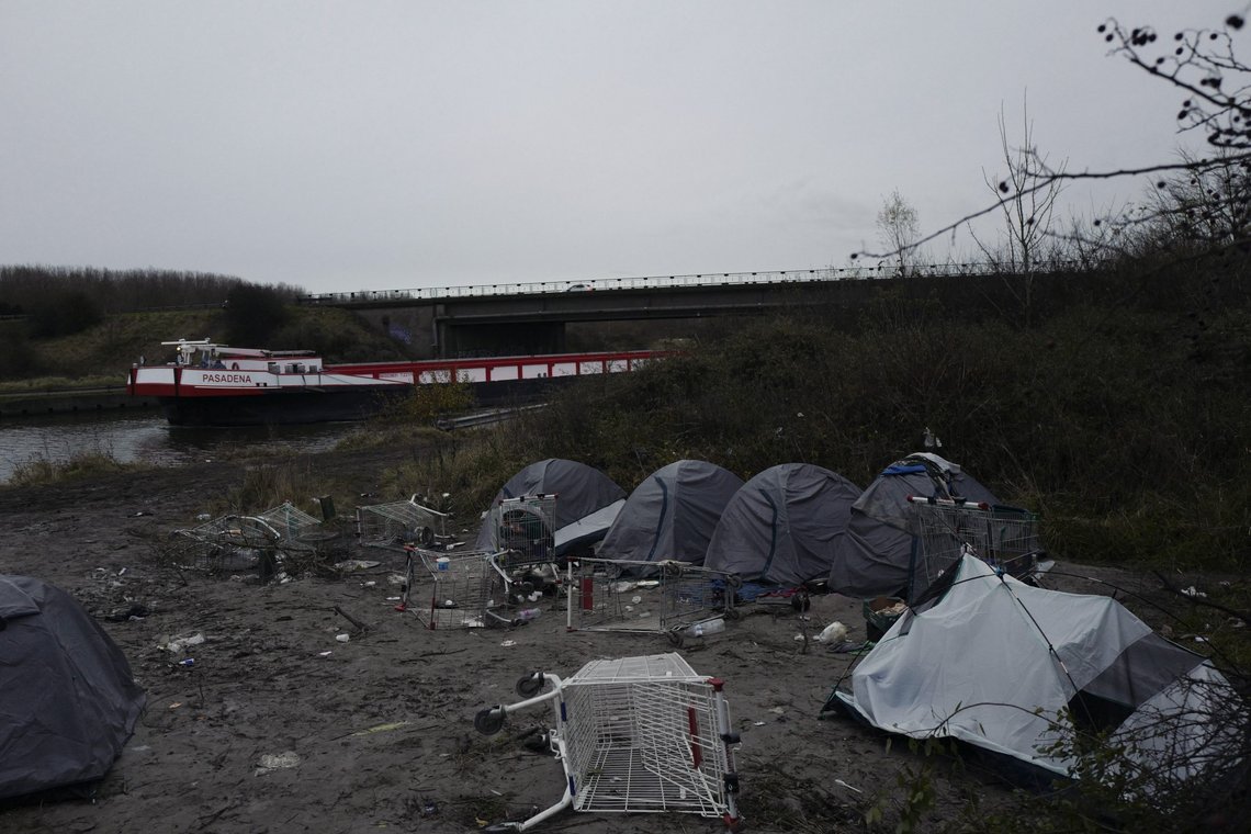 A migrants makeshift camp is set up along the river in Loon Plage, near Grande-Synthe, northern France, Friday, Nov. 26, 2021. Children and pregnant women were among at least 27 migrants who died when their small boat sank in an attempted crossing of the English Channel, a French government official said Thursday. (AP Photo/Rafael Yaghobzadeh) A migrants makeshift camp is set up along the river in Loon Plage, near Grande-Synthe, northern France, Friday, Nov. 26, 2021. Children and pregnant women were among at least 27 migrants who died when their small boat sank in an attempted crossing of the English Channel, a French government official said Thursday. (AP Photo/Rafael Yaghobzadeh)