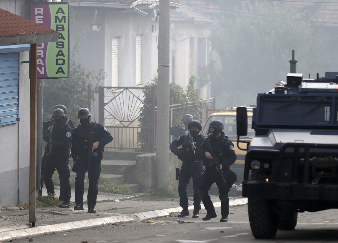 Kosovo police officers guard a street in the northern Serb-dominated part of ethnically divided town of Mitrovica, Kosovo, Wednesday, Oct. 13, 2021. Kosovo police have clashed with ethnic Serbs in the north during an operation against smuggling of goods. A police statement said that an operation against smuggled goods was held in four areas, including northern Mitrovica which is mostly populated by ethnic Serbs. (AP Photo/Bojan Slavkovic) Kosovo police officers guard a street in the northern Serb-dominated part of ethnically divided town of Mitrovica, Kosovo, Wednesday, Oct. 13, 2021. Kosovo police have clashed with ethnic Serbs in the north during an operation against smuggling of goods. A police statement said that an operation against smuggled goods was held in four areas, including northern Mitrovica which is mostly populated by ethnic Serbs. (AP Photo/Bojan Slavkovic)