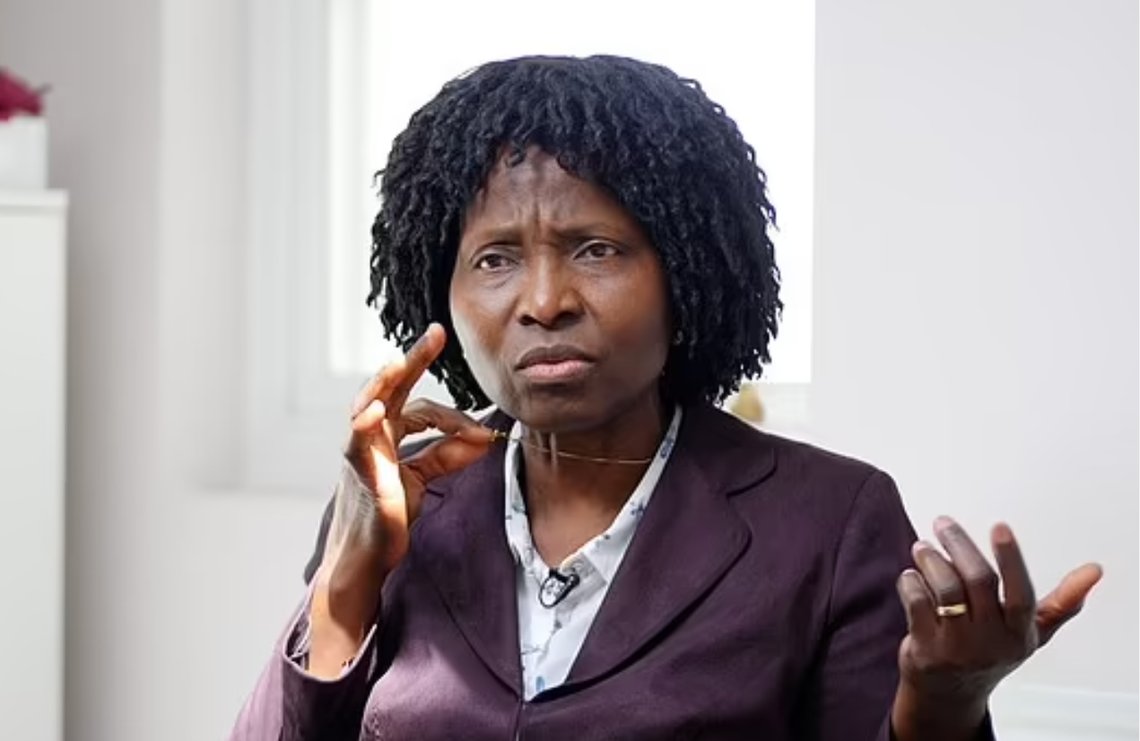 Mary Onuoha viser fram det lille gullkorset som førte til at hun mistet jobben som sykepleier etter 19 år. Skjermdump video/Daily Mail Mary Onuoha viser fram det lille gullkorset som førte til at hun mistet jobben som sykepleier etter 19 år. Skjermdump video/Daily Mail
