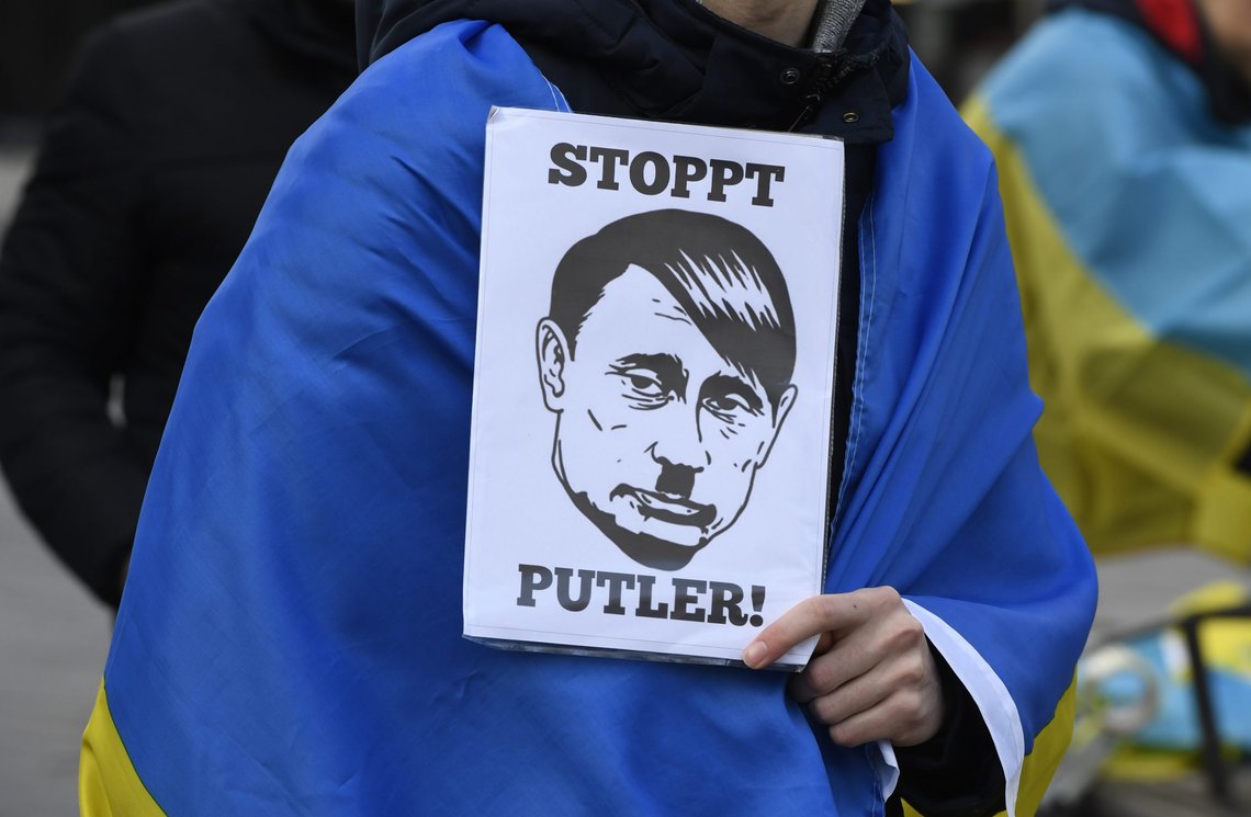 A demonstrator holds a sign with the inscription "Stop Putler" and the drawn likeness of Russia's President Putin, complemented with side parting and beard reminiscent of Hitler in Duesseldorf, Germany, Saturday, Feb. 26, 2022. Several hundred people demonstrated on Schadowplatz against Russia's attack on Ukraine. (Roberto Pfeil/dpa via AP) A demonstrator holds a sign with the inscription "Stop Putler" and the drawn likeness of Russia's President Putin, complemented with side parting and beard reminiscent of Hitler in Duesseldorf, Germany, Saturday, Feb. 26, 2022. Several hundred people demonstrated on Schadowplatz against Russia's attack on Ukraine. (Roberto Pfeil/dpa via AP)