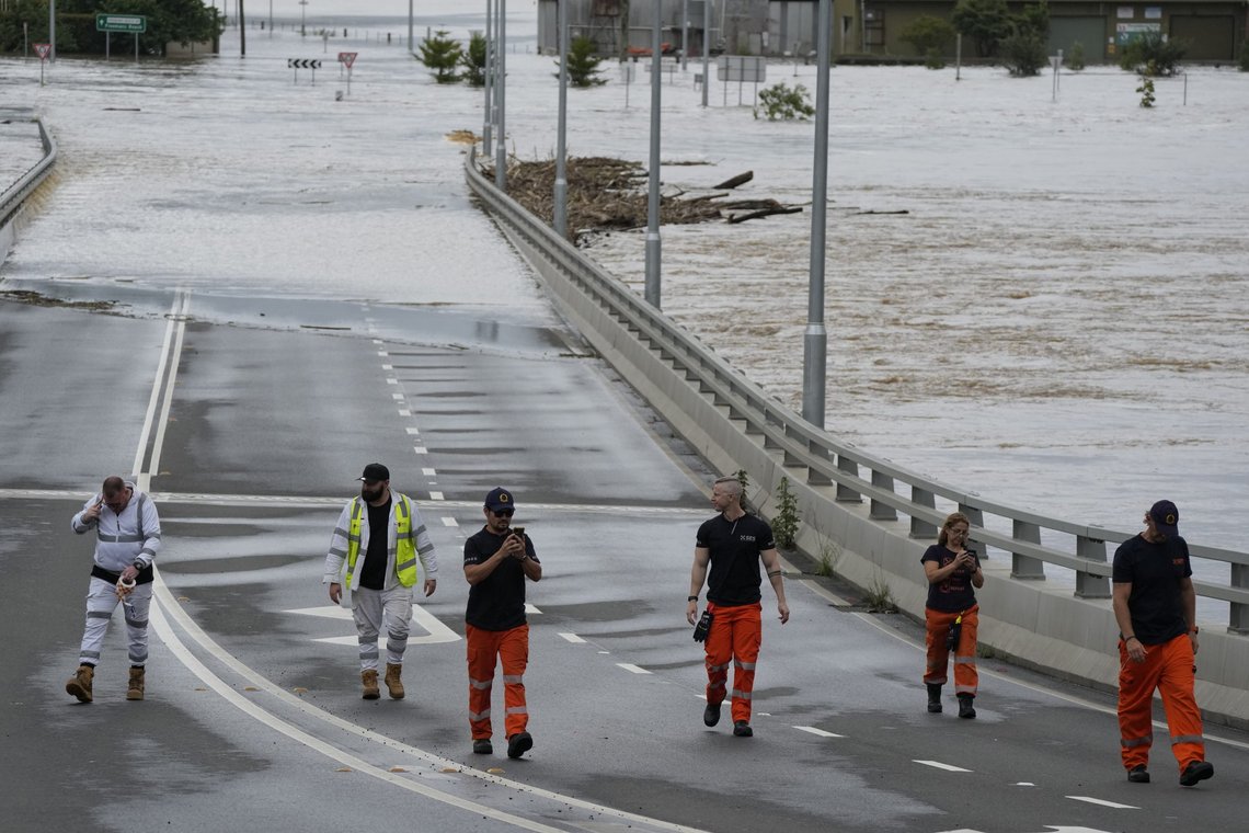 Nødetatene ved en oversvømt bro i utkanten av Sydney torsdag. Foto: Rick Rycroft / AP / NTB Nødetatene ved en oversvømt bro i utkanten av Sydney torsdag. Foto: Rick Rycroft / AP / NTB