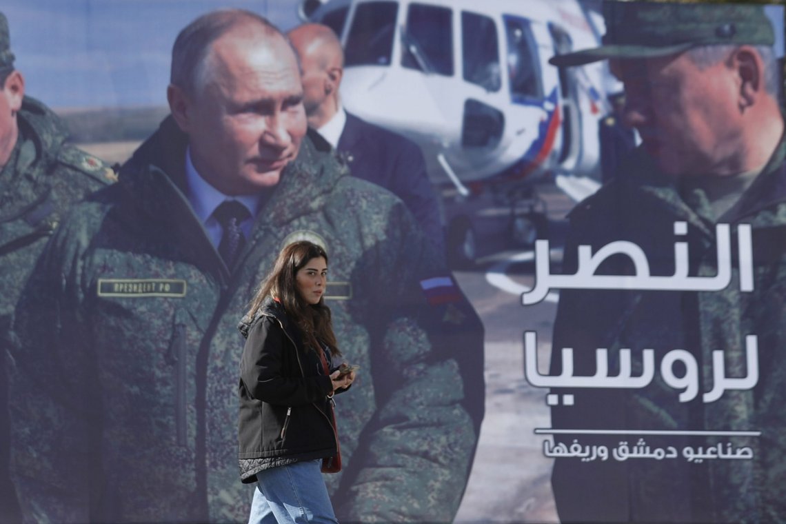 A woman passes a billboard showing Russian President Vladimir Putin in Damascus, Syria, Monday, March 7, 2022. The Arabic in poster reads, "The victory for Russia." (AP Photo/Omar Sanadiki) A woman passes a billboard showing Russian President Vladimir Putin in Damascus, Syria, Monday, March 7, 2022. The Arabic in poster reads, "The victory for Russia." (AP Photo/Omar Sanadiki)