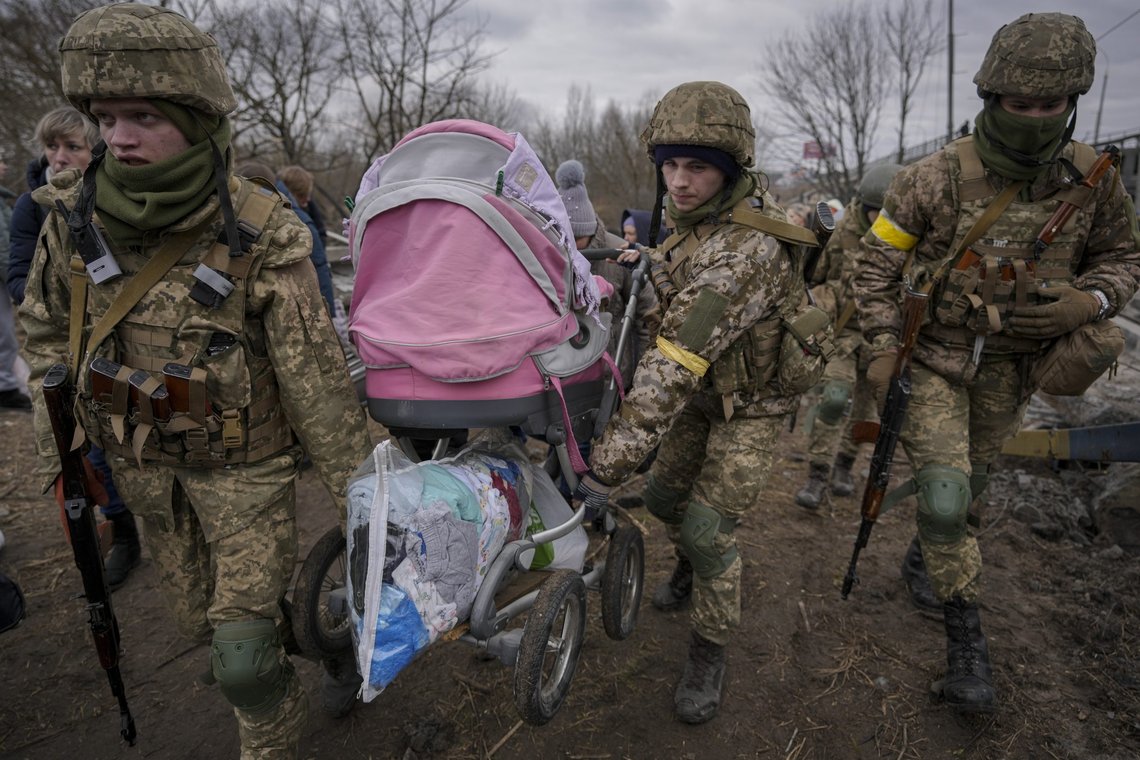 Ukrainian servicemen carry a baby stroller after crossing the Irpin River on an improvised path under a bridge that was destroyed by a Russian airstrike, while assisting people fleeing the town of Irpin, Ukraine, Saturday, March 5, 2022. (AP Photo/Vadim Ghirda) Ukrainian servicemen carry a baby stroller after crossing the Irpin River on an improvised path under a bridge that was destroyed by a Russian airstrike, while assisting people fleeing the town of Irpin, Ukraine, Saturday, March 5, 2022. (AP Photo/Vadim Ghirda)