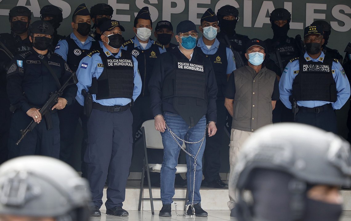 Hernandez (i lenker i midten) ble vist fram for pressen ved politiets hovedkvarter i hovedstaden Tegucigalpa etter pågripelsen i februar. Foto: Elmer Martinez / AP / NTB Hernandez (i lenker i midten) ble vist fram for pressen ved politiets hovedkvarter i hovedstaden Tegucigalpa etter pågripelsen i februar. Foto: Elmer Martinez / AP / NTB