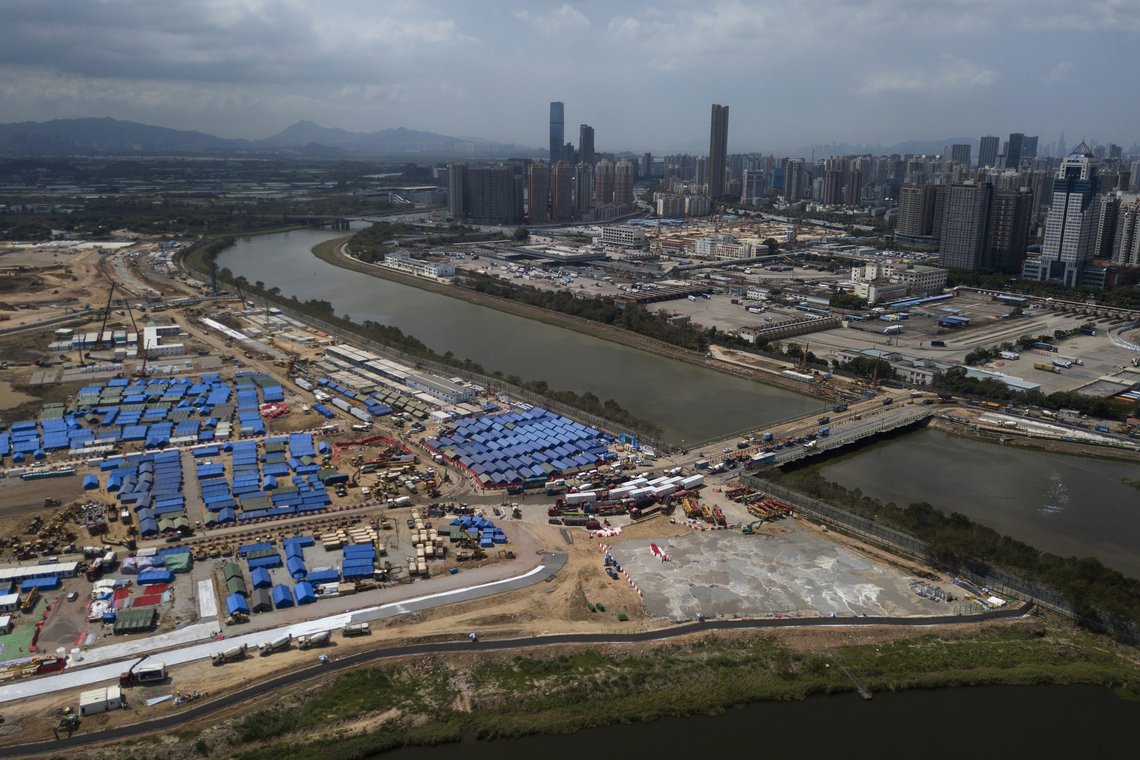 An aerial view shows the construction site for COVID-19 isolation facilities and a temporary bridge linked between China's Shenzhen and Hong Kong's Lok Ma Chau, Friday, March 11, 2022. Hong Kong, where experts say the city's worst outbreak to date may have peaked, barber shops and hair salons reopened Thursday. Still, many are seeing that as an example of mixed messages from the government of the semi-autonomous Chinese territory that has been ordered to follow the "zero tolerance" approach used on the mainland. (AP Photo/Kin Cheung) An aerial view shows the construction site for COVID-19 isolation facilities and a temporary bridge linked between China's Shenzhen and Hong Kong's Lok Ma Chau, Friday, March 11, 2022. Hong Kong, where experts say the city's worst outbreak to date may have peaked, barber shops and hair salons reopened Thursday. Still, many are seeing that as an example of mixed messages from the government of the semi-autonomous Chinese territory that has been ordered to follow the "zero tolerance" approach used on the mainland. (AP Photo/Kin Cheung)