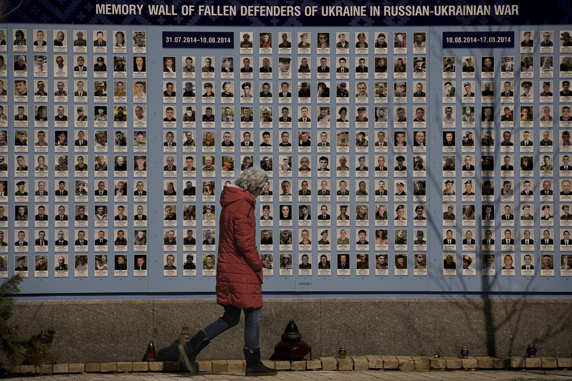 A woman walks by a memorial wall for those who lost their lives since the beginning of the conflict in Eastern Ukraine in Kyiv, Ukraine, Friday, March 18, 2022. Residents of the Ukrainian capital of Kyiv on took to a central square to arrange some 1.5 million tulips in the shape of the country's coat of arms, in a defiant show of normalcy as Russian forces surround and bomb the city. (AP Photo/Vadim Ghirda) A woman walks by a memorial wall for those who lost their lives since the beginning of the conflict in Eastern Ukraine in Kyiv, Ukraine, Friday, March 18, 2022. Residents of the Ukrainian capital of Kyiv on took to a central square to arrange some 1.5 million tulips in the shape of the country's coat of arms, in a defiant show of normalcy as Russian forces surround and bomb the city. (AP Photo/Vadim Ghirda)