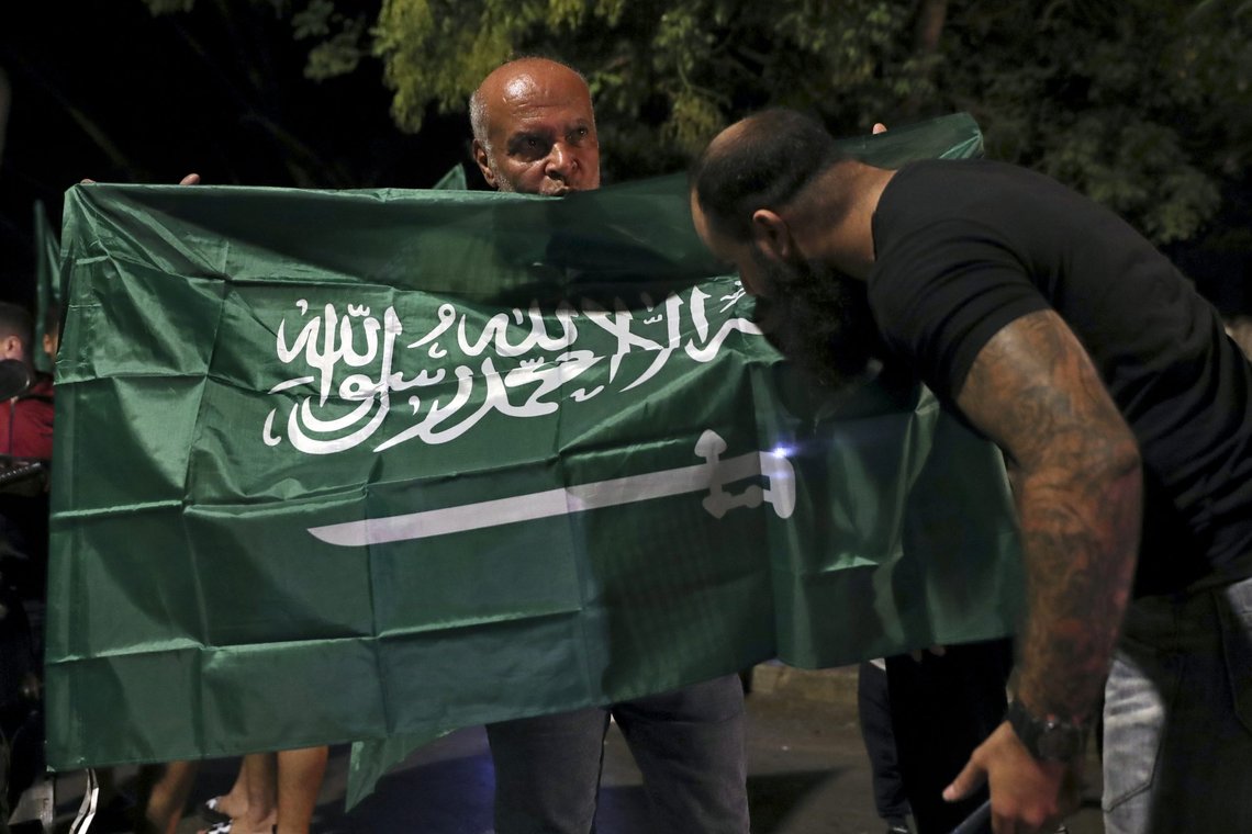 FILE - A Lebanese man kisses a Saudi Arabian flag during a rally in support of the kingdom and against comments made by Lebanon's Information Minister George Kordahi over the war in Yemen, in front of the Saudi Arabia Embassy in Beirut, Lebanon, Oct. 30, 2021. Job opportunities lost and contracts canceled are just some of the ways that ordinary Lebanese have been affected by Saudi Arabia’s furious backlash at Lebanon late last month. (AP Photo/Bilal Hussein, File) FILE - A Lebanese man kisses a Saudi Arabian flag during a rally in support of the kingdom and against comments made by Lebanon's Information Minister George Kordahi over the war in Yemen, in front of the Saudi Arabia Embassy in Beirut, Lebanon, Oct. 30, 2021. Job opportunities lost and contracts canceled are just some of the ways that ordinary Lebanese have been affected by Saudi Arabia’s furious backlash at Lebanon late last month. (AP Photo/Bilal Hussein, File)