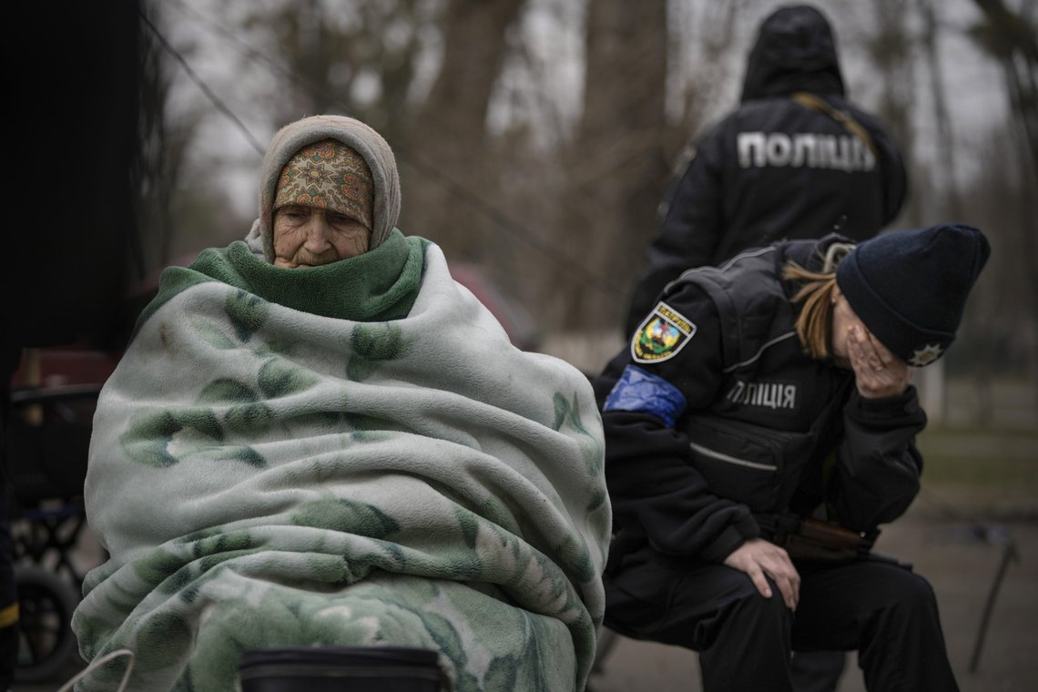 En Ukrainsk politibetjent overveldes av følelser etter å ha trøstet folk som evakueres fra Irpin ved Kyiv lørdag. Kvinnen som er inntyllet i et pledd er 94 år. Foto: Vadim Ghirda / AP / NTB En Ukrainsk politibetjent overveldes av følelser etter å ha trøstet folk som evakueres fra Irpin ved Kyiv lørdag. Kvinnen som er inntyllet i et pledd er 94 år. Foto: Vadim Ghirda / AP / NTB