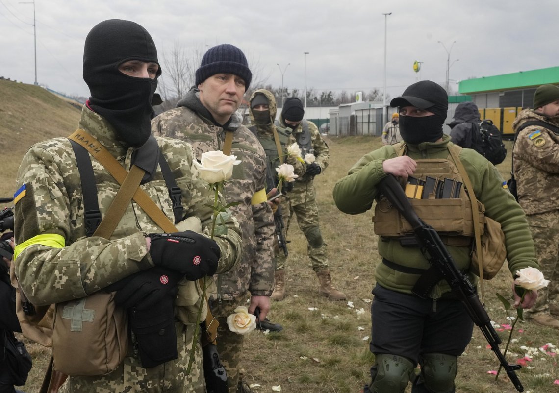 Medlemmer av de ukrainske forsvarsstyrkene med blomster under bryllupsseremonien for sine soldater, Lesia Ivashchenko og Valerii Fylymonov, på et kontrollpunkt i Kyiv, Ukraina, søndag 6. mars 2022. På dag 11 i Russlands krig på Ukraina, har russiske styrker beskutt omringede byer, og et forsøk på å evakuere sivile fra den beleirede havnebyen Mariupol mislyktes på grunn av fortsatte kamphandlinger. Foto: Efrem Lukatsky / AP / NTB Medlemmer av de ukrainske forsvarsstyrkene med blomster under bryllupsseremonien for sine soldater, Lesia Ivashchenko og Valerii Fylymonov, på et kontrollpunkt i Kyiv, Ukraina, søndag 6. mars 2022. På dag 11 i Russlands krig på Ukraina, har russiske styrker beskutt omringede byer, og et forsøk på å evakuere sivile fra den beleirede havnebyen Mariupol mislyktes på grunn av fortsatte kamphandlinger. Foto: Efrem Lukatsky / AP / NTB