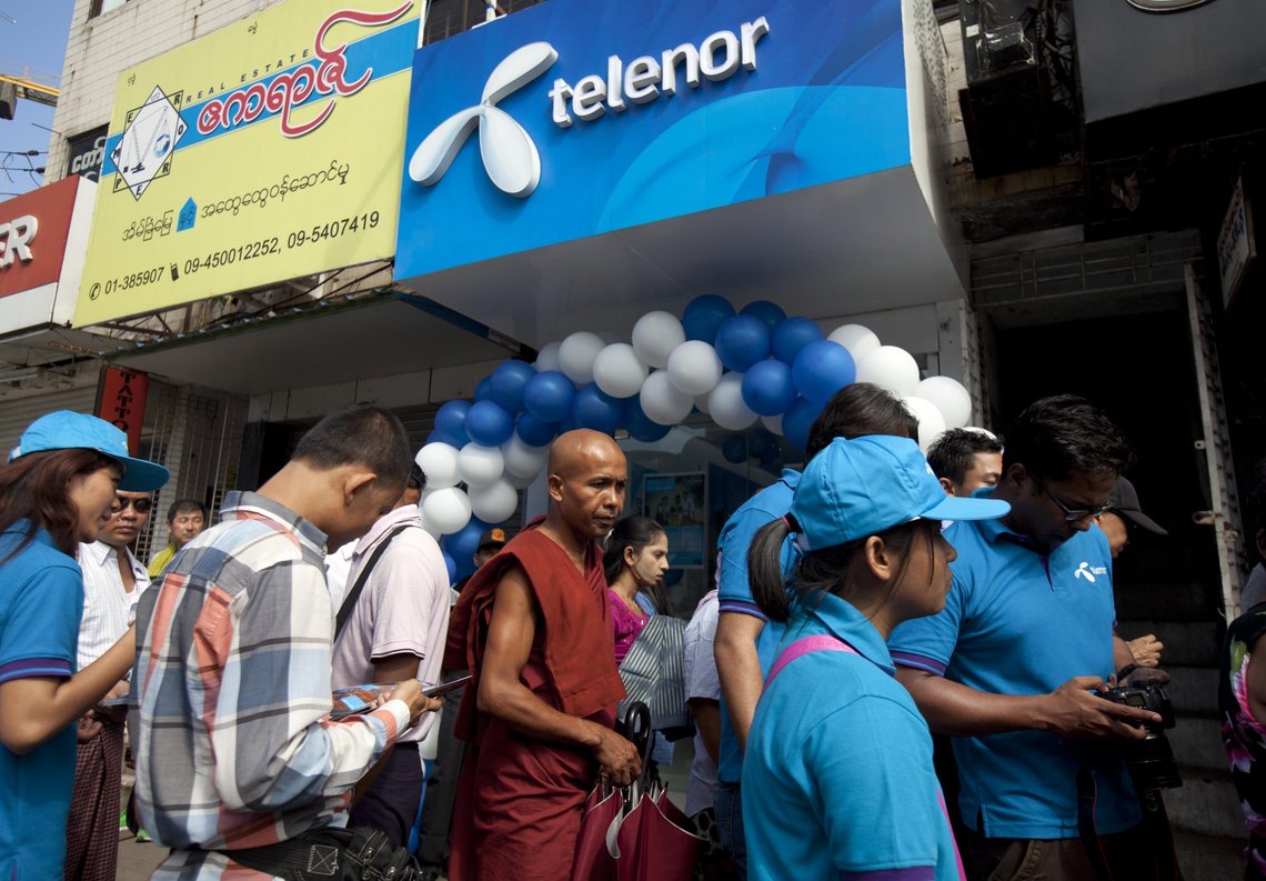FILE - Customers line up outside a showroom to buy SIM cards at Telenor telecommunication company, in Yangon, Myanmar, Oct. 26, 2014. Norwegian telecoms giant Telenor said Friday that regulators in Myanmar have approved its plan to sell its business there. (AP Photo/Khin Maung Win, File) FILE - Customers line up outside a showroom to buy SIM cards at Telenor telecommunication company, in Yangon, Myanmar, Oct. 26, 2014. Norwegian telecoms giant Telenor said Friday that regulators in Myanmar have approved its plan to sell its business there. (AP Photo/Khin Maung Win, File)