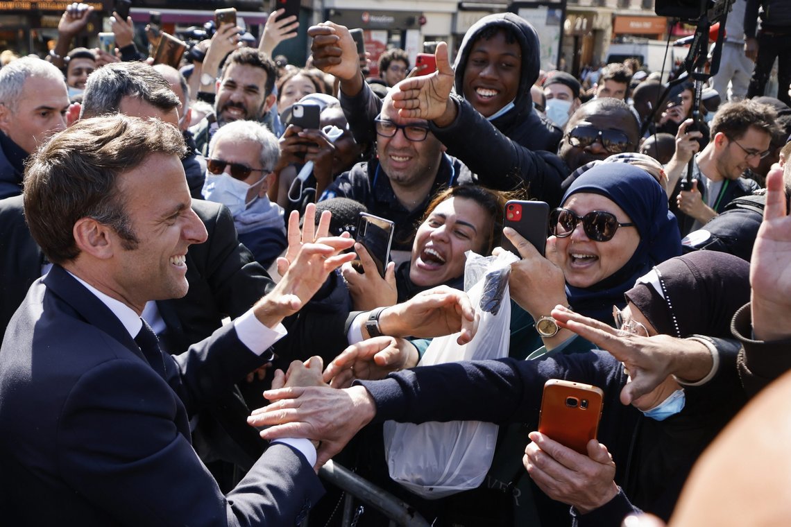 Centrist presidential candidate and French President Emmanuel Macron holds hands to residents during a campaign stop Thursday, April 21, 2022 in Saint-Denis, outside Paris. French voters head to polls on Sunday in a runoff vote between centrist incumbent Emmanuel Macron and nationalist rival Marine Le Pen. (Ludovic Marin, Pool via AP) Centrist presidential candidate and French President Emmanuel Macron holds hands to residents during a campaign stop Thursday, April 21, 2022 in Saint-Denis, outside Paris. French voters head to polls on Sunday in a runoff vote between centrist incumbent Emmanuel Macron and nationalist rival Marine Le Pen. (Ludovic Marin, Pool via AP)