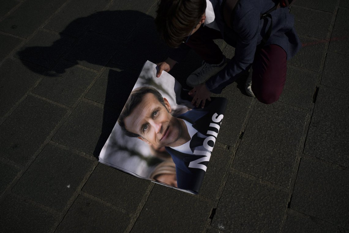 A campaign volunteer folds a poster of French President Emmanuel Macron and centrist candidate for re-election in Marseille, southern France, Friday, April 22, 2022. The finalists for France’s presidency, President Emmanuel Macron and far-right leader Marine Le Pen, traded blows on the last day of legal campaigning as they tried to appeal to undecided voters. Macron, the center-right incumbent, laid into the nationalist challenger he defeated in 2017 and is set to face again in a Sunday runoff. (AP Photo/Daniel Cole) A campaign volunteer folds a poster of French President Emmanuel Macron and centrist candidate for re-election in Marseille, southern France, Friday, April 22, 2022. The finalists for France’s presidency, President Emmanuel Macron and far-right leader Marine Le Pen, traded blows on the last day of legal campaigning as they tried to appeal to undecided voters. Macron, the center-right incumbent, laid into the nationalist challenger he defeated in 2017 and is set to face again in a Sunday runoff. (AP Photo/Daniel Cole)