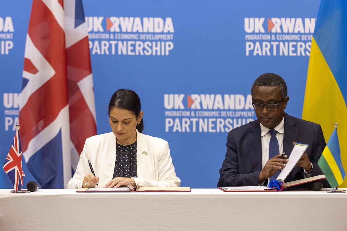 Innenriksminister Priti Patel, og Rwandas utenriksminister Vincent Biruta signerer avtalen som de kaller "et økonomisk utviklingssamarbeid". (AP Photo/Muhizi Olivier) Innenriksminister Priti Patel, og Rwandas utenriksminister Vincent Biruta signerer avtalen som de kaller "et økonomisk utviklingssamarbeid". (AP Photo/Muhizi Olivier)