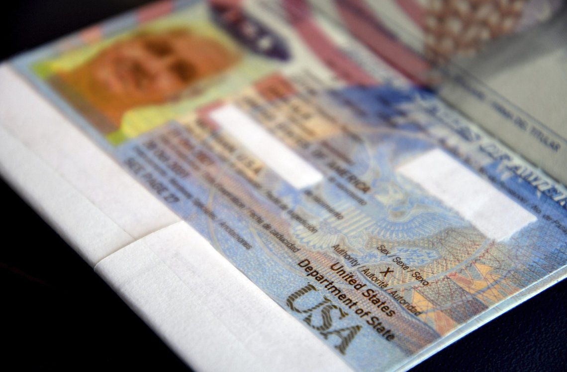 PASSPORT REDACTED WITH WHITE TAPE BY PASSPORT HOLDER - A passport belonging to Dana Zzyym rests on a table, Wednesday, Oct. 27, 2021, in Fort Collins, Colo. Zzyym, who prefers a gender-neutral pronoun, told the Associated Press that their passport is the first U.S. passport to be issued with an "X" gender designation, marking a milestone in the recognition of the rights of people who do not identify as male or female. Zzyym used white tape to redact parts of the passport. (AP Photo/Thomas Peipert) PASSPORT REDACTED WITH WHITE TAPE BY PASSPORT HOLDER - A passport belonging to Dana Zzyym rests on a table, Wednesday, Oct. 27, 2021, in Fort Collins, Colo. Zzyym, who prefers a gender-neutral pronoun, told the Associated Press that their passport is the first U.S. passport to be issued with an "X" gender designation, marking a milestone in the recognition of the rights of people who do not identify as male or female. Zzyym used white tape to redact parts of the passport. (AP Photo/Thomas Peipert)