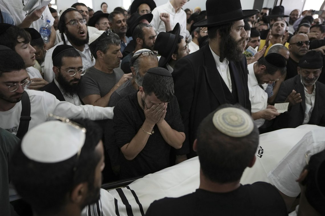 Jewish mourners gather in Petah Tikva, Israel at the funeral for Yonatan Havakuk, the day after he was killed with two others in a stabbing attack in Elad, Friday, May 6, 2022. Israeli security forces waged a massive manhunt Friday for two Palestinians suspected of carrying out the stabbing attack on Thursday near Tel Aviv that left three Israelis dead.(AP Photo/Ariel Schalit) Jewish mourners gather in Petah Tikva, Israel at the funeral for Yonatan Havakuk, the day after he was killed with two others in a stabbing attack in Elad, Friday, May 6, 2022. Israeli security forces waged a massive manhunt Friday for two Palestinians suspected of carrying out the stabbing attack on Thursday near Tel Aviv that left three Israelis dead.(AP Photo/Ariel Schalit)