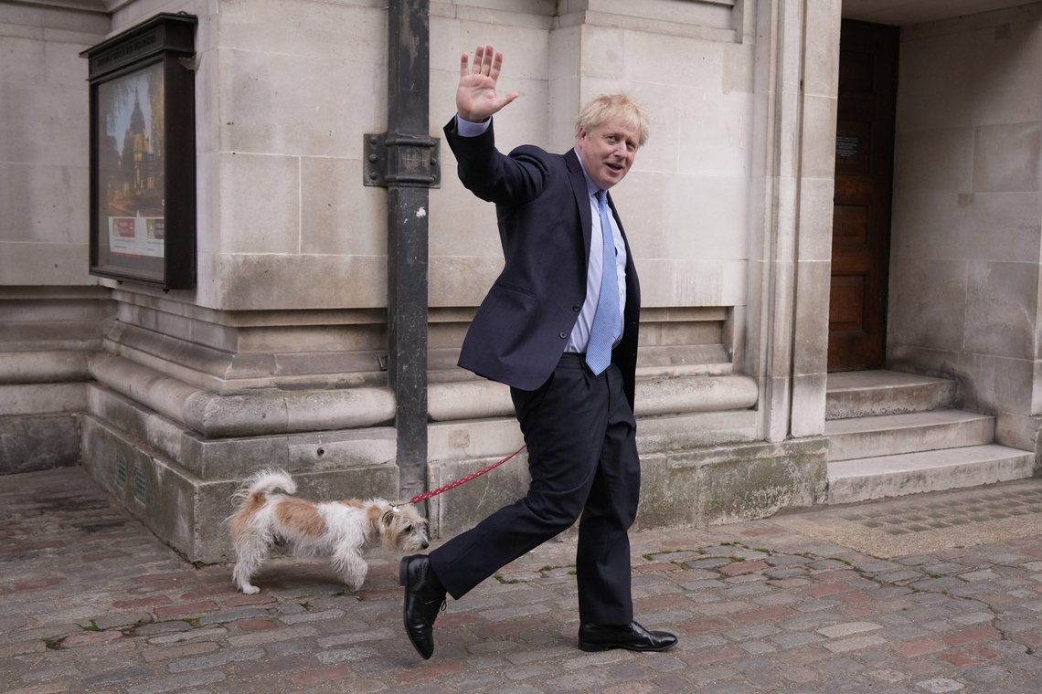 Britain's Prime Minister Boris Johnson waves at the media as he leaves with his dog Dilyn after voting at a polling station in London, for local council elections, Thursday, May 5, 2022. (AP Photo/Matt Dunham) Britain's Prime Minister Boris Johnson waves at the media as he leaves with his dog Dilyn after voting at a polling station in London, for local council elections, Thursday, May 5, 2022. (AP Photo/Matt Dunham)