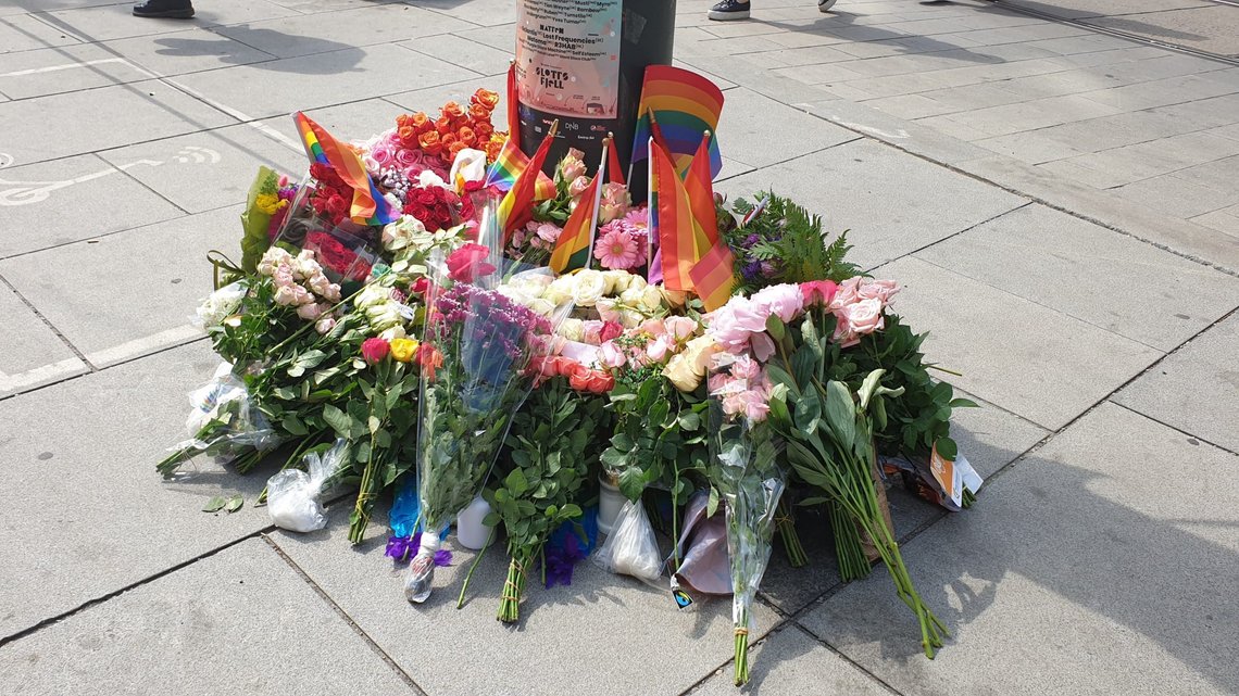 Blomsterhav og regnbueflagg utenfor utestedene som ble angrepet natt til 25. juni. Politiet etterforsker om hatkriminalitet var motiv for skytingen som krevde to menneskeliv. Foto: Hanne Tolg Blomsterhav og regnbueflagg utenfor utestedene som ble angrepet natt til 25. juni. Politiet etterforsker om hatkriminalitet var motiv for skytingen som krevde to menneskeliv. Foto: Hanne Tolg