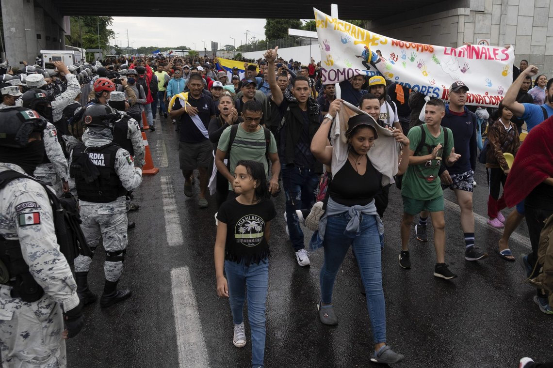 Migrants walk past Mexican National Guards as they leave the city of Tapachula in Chiapas state, Mexico, early Monday, June 6, 2022. Several thousand migrants set out walking in the rain early Monday in southern Mexico, tired of waiting to normalize their status in a region with little work still far from their ultimate goal of reaching the United States. (AP Photo/Isabel Mateos) Migrants walk past Mexican National Guards as they leave the city of Tapachula in Chiapas state, Mexico, early Monday, June 6, 2022. Several thousand migrants set out walking in the rain early Monday in southern Mexico, tired of waiting to normalize their status in a region with little work still far from their ultimate goal of reaching the United States. (AP Photo/Isabel Mateos)
