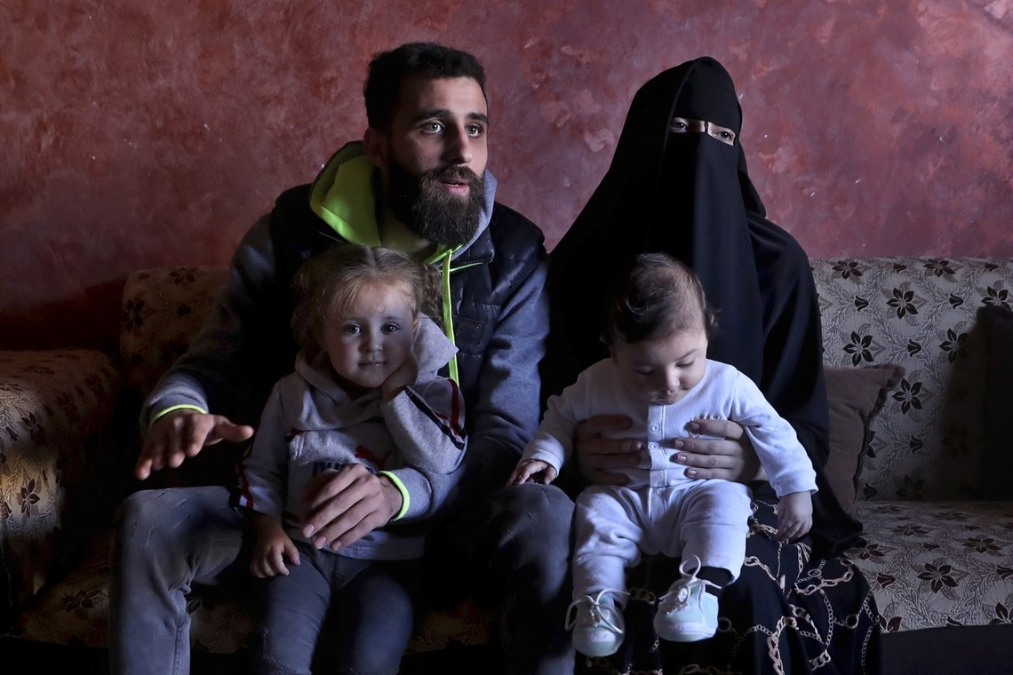 Ziad Khaled Hilweh, 23, who tried to migrate to Europe with his family, speaks during an interview as he sits with his wife Alaa Khodr, 22, his daughter Jana 2 year-old and his son Karim 3 months, at his parents house in the northern city of Tripoli, Lebanon, Monday, Dec. 6, 2021. Lebanese are setting off from the port city of Tripoli to attempt the perilous journey by boat to Cyprus and beyond in the hopes of reaching Europe. They are joining Iraqis, Afghans and Sudanese in leaving their homeland after Lebanon's economic collapse has thrown two-thirds of the population into poverty in just over a year. (AP Photo/Bilal Hussein) Ziad Khaled Hilweh, 23, who tried to migrate to Europe with his family, speaks during an interview as he sits with his wife Alaa Khodr, 22, his daughter Jana 2 year-old and his son Karim 3 months, at his parents house in the northern city of Tripoli, Lebanon, Monday, Dec. 6, 2021. Lebanese are setting off from the port city of Tripoli to attempt the perilous journey by boat to Cyprus and beyond in the hopes of reaching Europe. They are joining Iraqis, Afghans and Sudanese in leaving their homeland after Lebanon's economic collapse has thrown two-thirds of the population into poverty in just over a year. (AP Photo/Bilal Hussein)