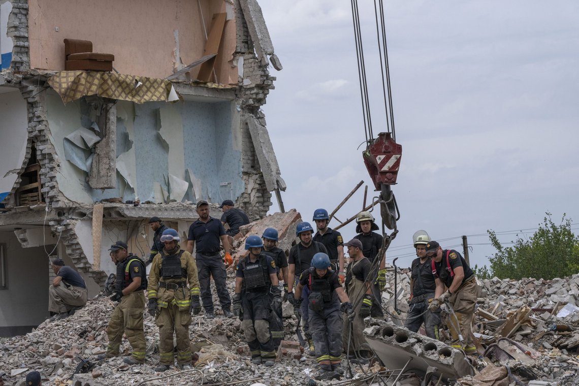 Rescue workers sift through rubble at the scene in the after math of a Russian rocket that hit an apartment residential block, in Chasiv Yar, Donetsk region, eastern Ukraine, Sunday, July 10, 2022. At least 15 people were killed and more than 20 people may still be trapped in the rubble, officials said Sunday. (AP Photo/Nariman El-Mofty) Rescue workers sift through rubble at the scene in the after math of a Russian rocket that hit an apartment residential block, in Chasiv Yar, Donetsk region, eastern Ukraine, Sunday, July 10, 2022. At least 15 people were killed and more than 20 people may still be trapped in the rubble, officials said Sunday. (AP Photo/Nariman El-Mofty)