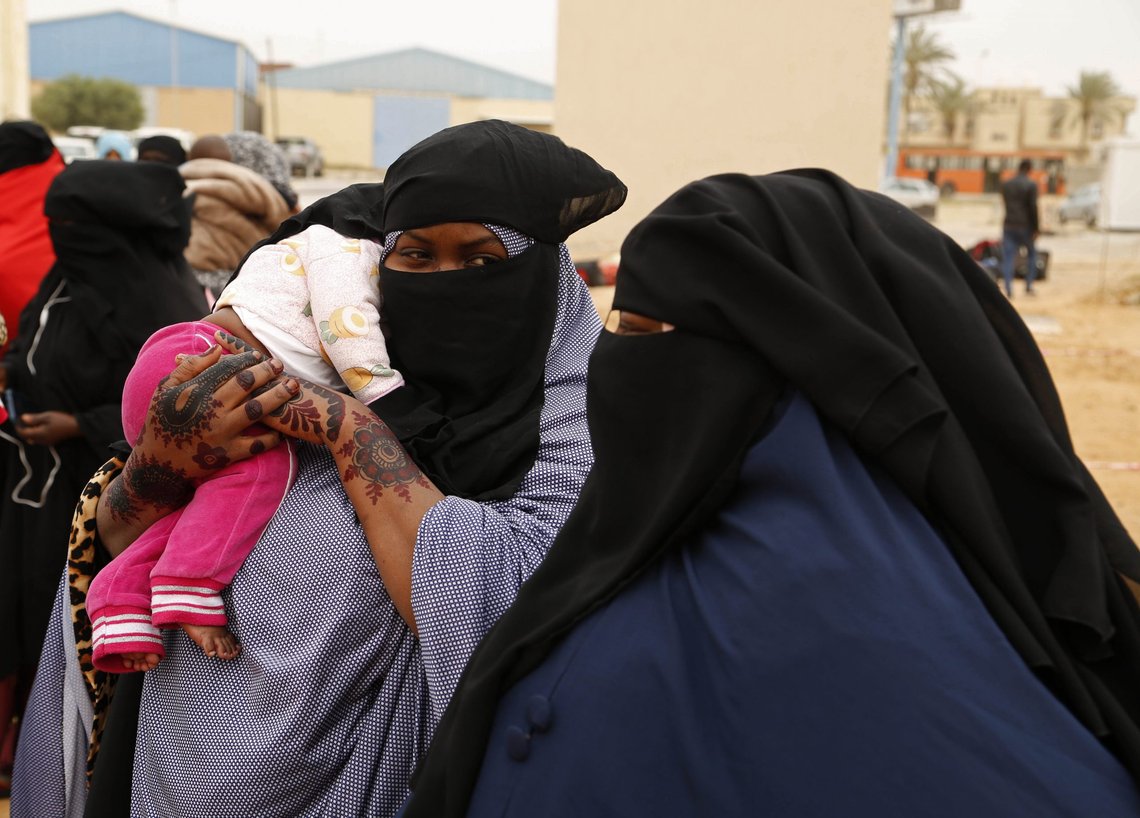 Migrants wait to board a flight to Niger, in Misrata, Libya, Thursday, April. 21, 2022. The Libyan authorities, in cooperation with the International Organization for Migration (IOM), repatriated 160 migrants from Niger resuming voluntary flights to deport migrants from the country. (AP Photo/Yousef Murad) Migrants wait to board a flight to Niger, in Misrata, Libya, Thursday, April. 21, 2022. The Libyan authorities, in cooperation with the International Organization for Migration (IOM), repatriated 160 migrants from Niger resuming voluntary flights to deport migrants from the country. (AP Photo/Yousef Murad)