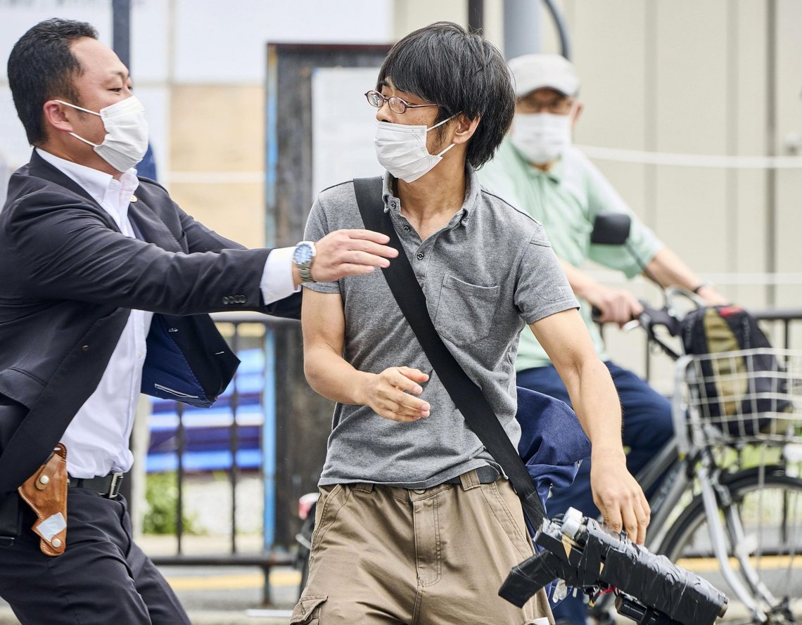FILE - Tetsuya Yamagami, center, holding a weapon, is detained near the site of gunshots in Nara, western Japan, Friday, July 8, 2022. The 40-centimeter-long (16-inch) firearm that was used to kill former Prime Minister Shinzo Abe on Friday as he campaigned for his ruling party in Nara, western Japan, looked crude, more like a propellant made of pipes taped together and filled with explosives. (Nara Shimbun/Kyodo News via AP, File) FILE - Tetsuya Yamagami, center, holding a weapon, is detained near the site of gunshots in Nara, western Japan, Friday, July 8, 2022. The 40-centimeter-long (16-inch) firearm that was used to kill former Prime Minister Shinzo Abe on Friday as he campaigned for his ruling party in Nara, western Japan, looked crude, more like a propellant made of pipes taped together and filled with explosives. (Nara Shimbun/Kyodo News via AP, File)