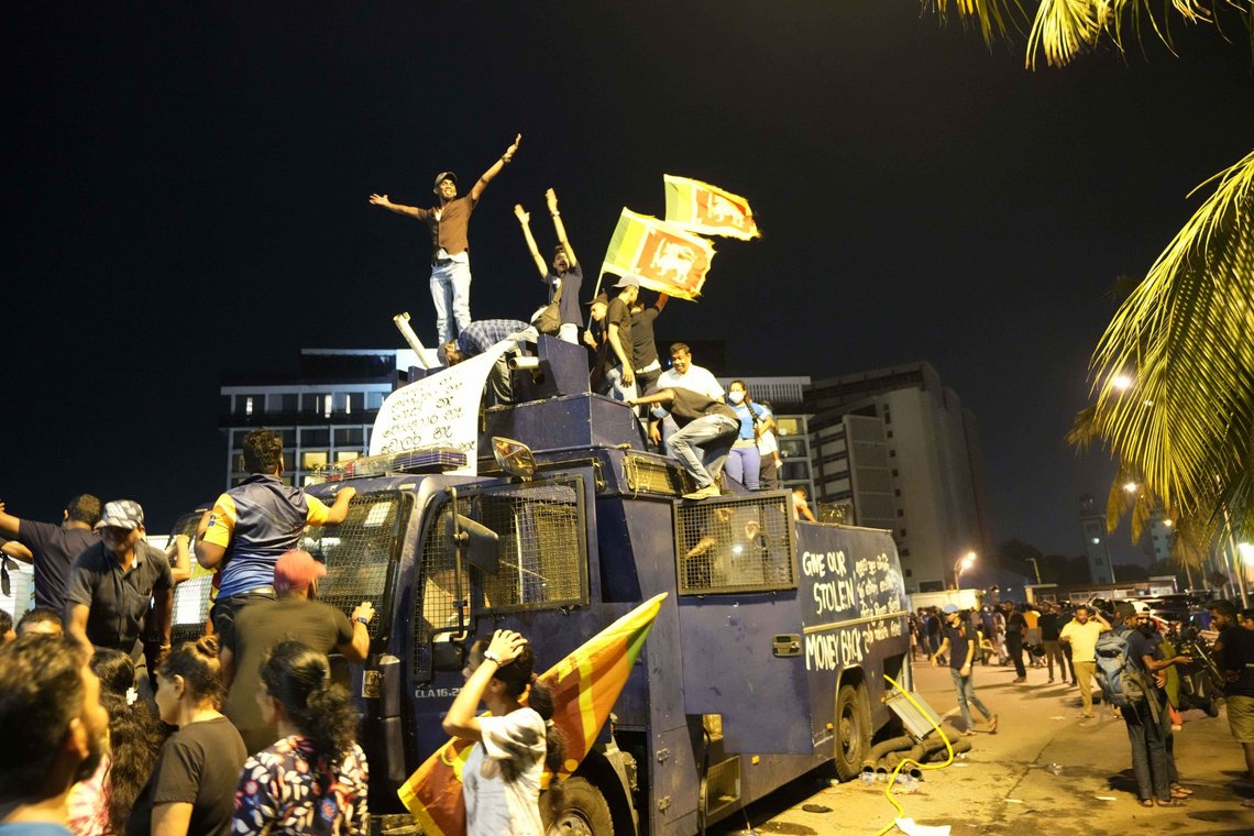 Protesters stand on a vandalised police water canon truck and shout slogans at the entrance to president's official residence in Colombo, Sri Lanka, Saturday, July 9, 2022. (AP Photo/Eranga Jayawardena) Protesters stand on a vandalised police water canon truck and shout slogans at the entrance to president's official residence in Colombo, Sri Lanka, Saturday, July 9, 2022. (AP Photo/Eranga Jayawardena)
