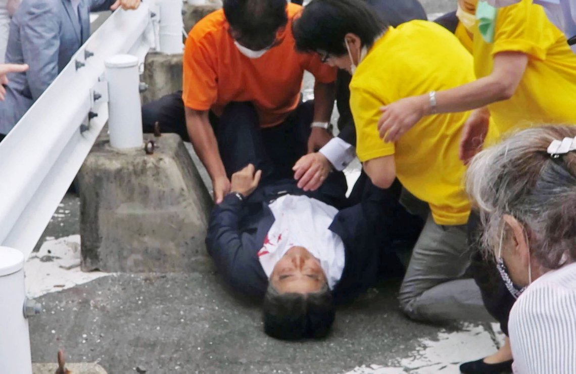 In this image from a video, Japan’s former Prime Minister Shinzo Abe, center, is attended on the ground in Nara, western Japan Friday, July 8, 2022. Former Japanese Prime Minister Shinzo Abe, a divisive arch-conservative and one of his nation's most powerful and influential figures, has died after being shot during a campaign speech Friday in western Japan, hospital officials said. (Kyodo News via AP) In this image from a video, Japan’s former Prime Minister Shinzo Abe, center, is attended on the ground in Nara, western Japan Friday, July 8, 2022. Former Japanese Prime Minister Shinzo Abe, a divisive arch-conservative and one of his nation's most powerful and influential figures, has died after being shot during a campaign speech Friday in western Japan, hospital officials said. (Kyodo News via AP)