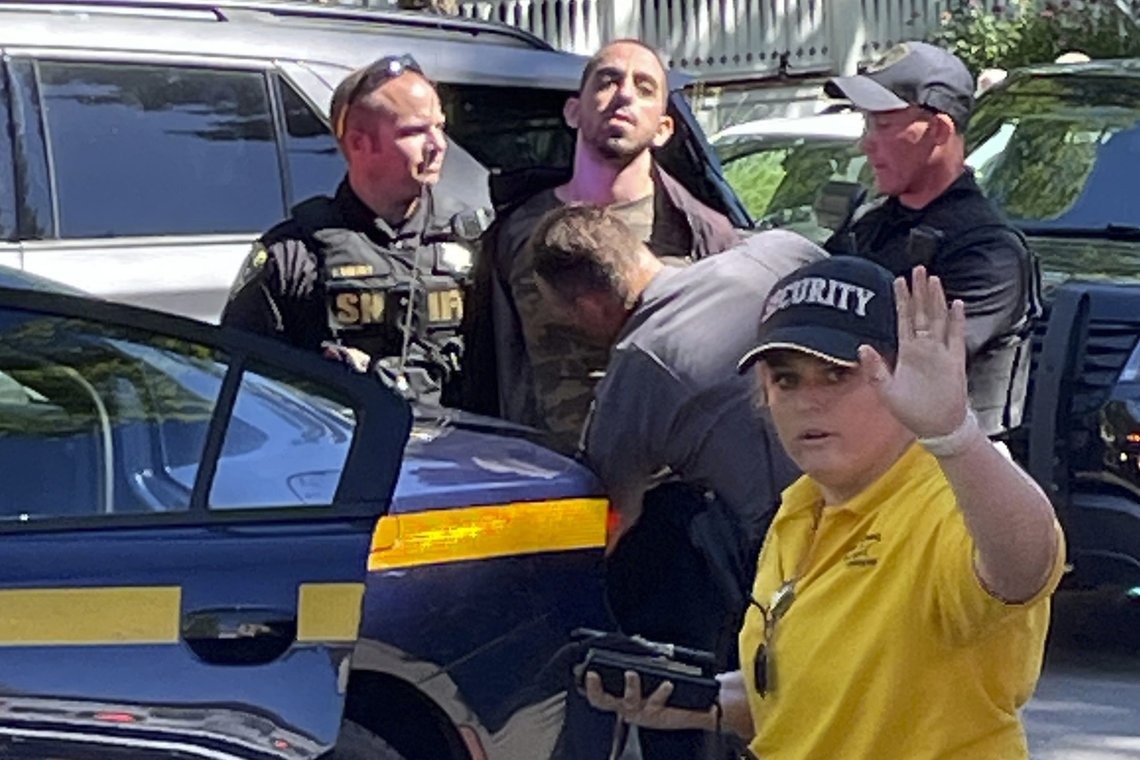 Law enforcement officers detain a person outside the Chautauqua Institution, Friday, Aug. 12, 2022, in Chautauqua, N.Y.. Salman Rushdie, the author whose writing led to death threats from Iran in the 1980s, was attacked and apparently stabbed in the neck Friday by a man who rushed the stage as he was about to give a lecture at the institute in western New York. (Charles Fox via AP) Law enforcement officers detain a person outside the Chautauqua Institution, Friday, Aug. 12, 2022, in Chautauqua, N.Y.. Salman Rushdie, the author whose writing led to death threats from Iran in the 1980s, was attacked and apparently stabbed in the neck Friday by a man who rushed the stage as he was about to give a lecture at the institute in western New York. (Charles Fox via AP)