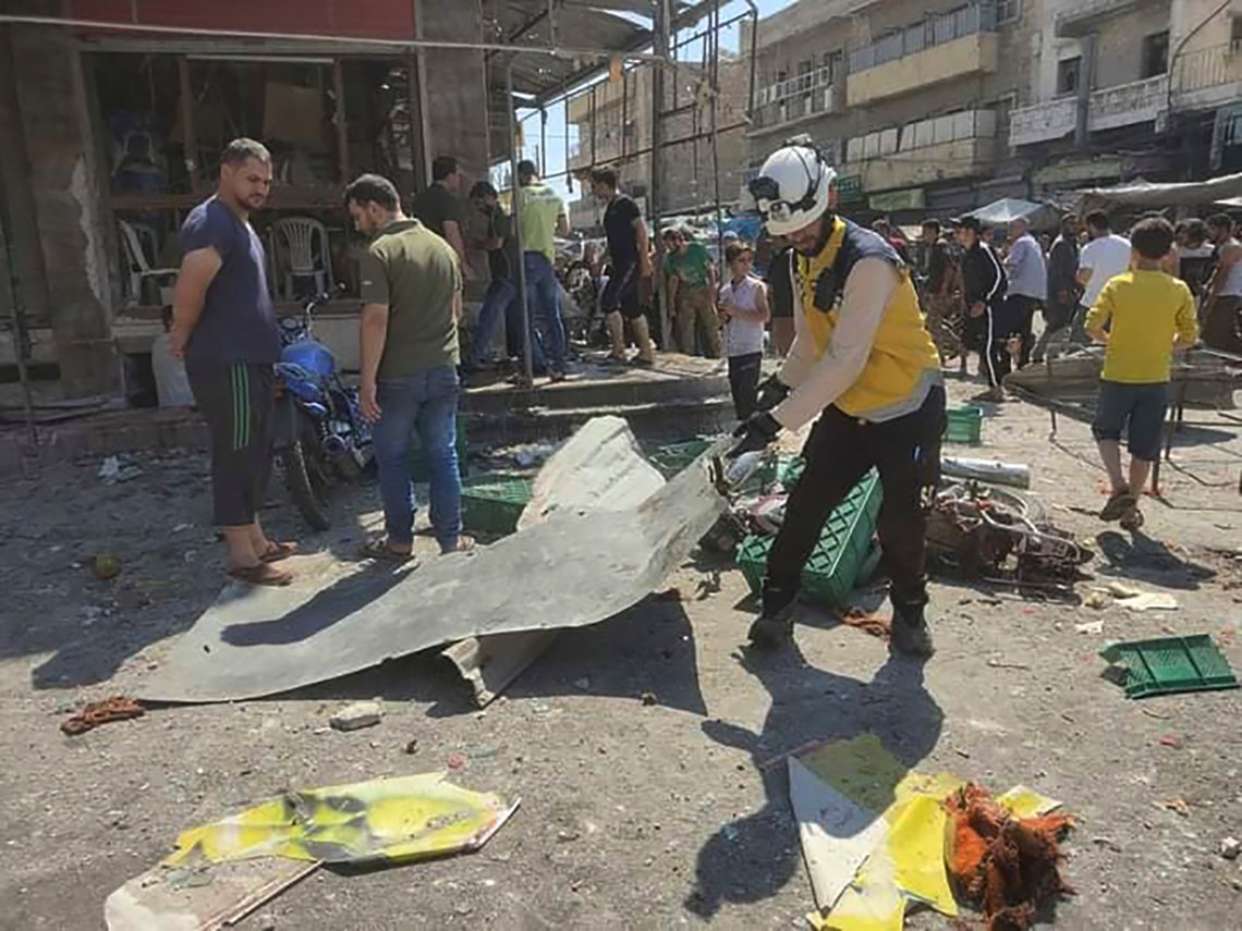 This photo provided by the Syrian Civil Defense White Helmets, which has been authenticated based on its contents and other AP reporting, shows a Syrian White Helmet civil defense worker, center, works at the rocket attacked scene, at al-Bab town, north Syria, Friday, Aug. 19, 2022. A rocket attack on a crowded market in a town held by Turkey-backed opposition fighters in northern Syria Friday killed several people and wounded dozens, an opposition war monitor and a paramedic group reported. (Syrian Civil Defense White Helmets via AP) This photo provided by the Syrian Civil Defense White Helmets, which has been authenticated based on its contents and other AP reporting, shows a Syrian White Helmet civil defense worker, center, works at the rocket attacked scene, at al-Bab town, north Syria, Friday, Aug. 19, 2022. A rocket attack on a crowded market in a town held by Turkey-backed opposition fighters in northern Syria Friday killed several people and wounded dozens, an opposition war monitor and a paramedic group reported. (Syrian Civil Defense White Helmets via AP)