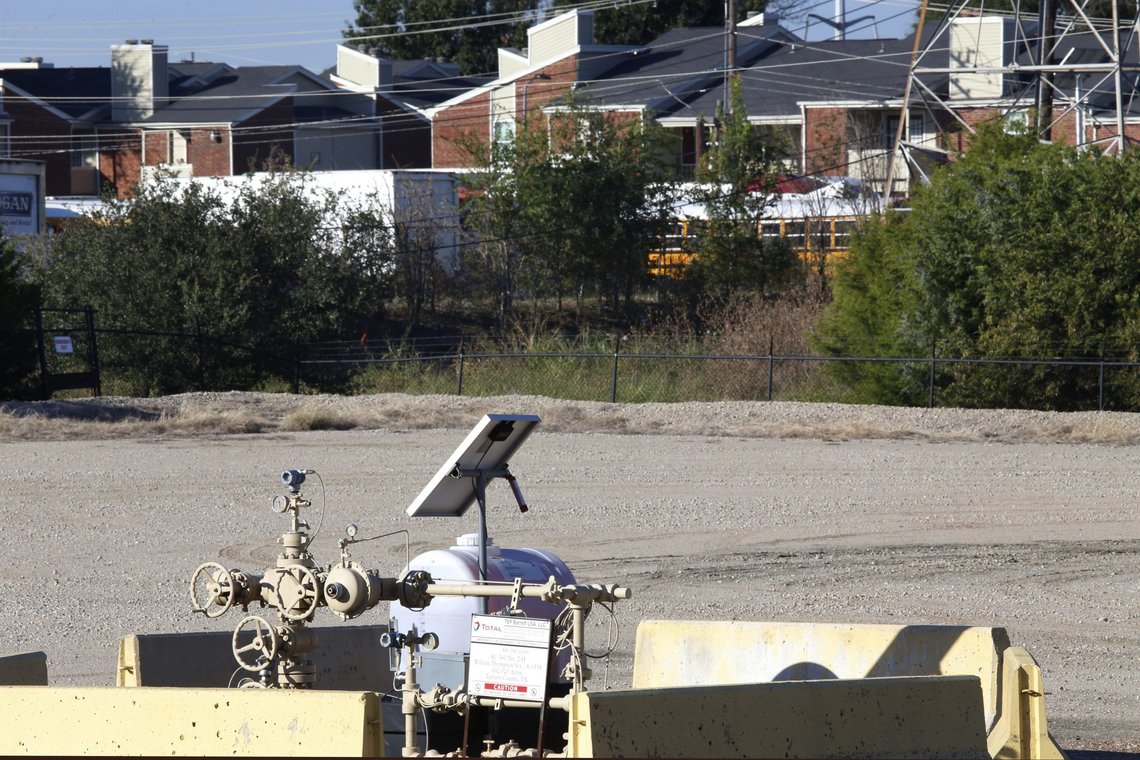 FILE - A natural gas well is juxtaposed with apartment buildings a few hundred feet away in Arlington, Texas, on Monday, Oct. 25, 2021. The site, known as "AC-360," is operated by TEP Barnett, a subsidiary of French energy giant Total Energies. On Tuesday, Jan. 4, 2022, the Arlington City Council voted 5-4 to reject the request by Total Energies to drill additional gas wells, reversing a preliminary decision by the council in November to allow the wells to go forward. (AP Photo/Martha Irvine, File) FILE - A natural gas well is juxtaposed with apartment buildings a few hundred feet away in Arlington, Texas, on Monday, Oct. 25, 2021. The site, known as "AC-360," is operated by TEP Barnett, a subsidiary of French energy giant Total Energies. On Tuesday, Jan. 4, 2022, the Arlington City Council voted 5-4 to reject the request by Total Energies to drill additional gas wells, reversing a preliminary decision by the council in November to allow the wells to go forward. (AP Photo/Martha Irvine, File)