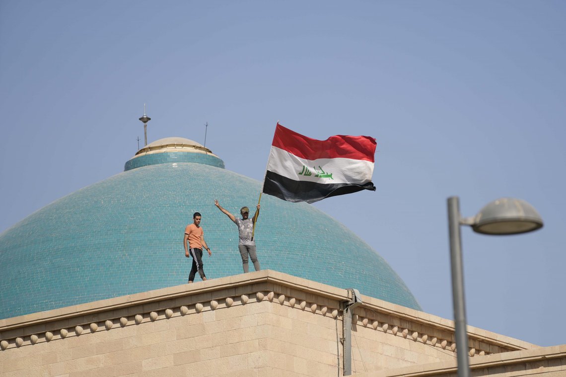 To tilhengere av sjialederen Moqtada al-Sadr på taket av regjeringspalasset i Bagdad. Foto: AP / NTB To tilhengere av sjialederen Moqtada al-Sadr på taket av regjeringspalasset i Bagdad. Foto: AP / NTB