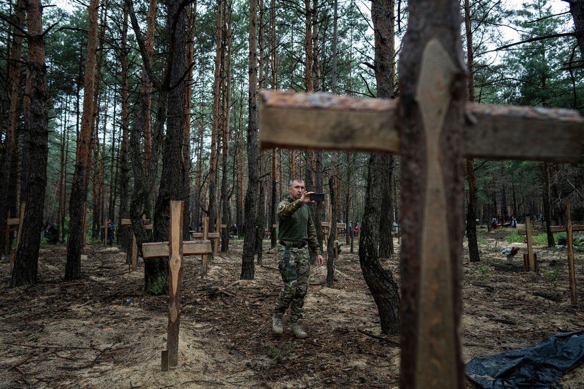 Den ukrainske etterforskeren Oleh Kotenko tar bilder og sikrer spor på massegraven som er funnet i Izium. Foto: Jevhen Maloletka/ AP/ NTB Den ukrainske etterforskeren Oleh Kotenko tar bilder og sikrer spor på massegraven som er funnet i Izium. Foto: Jevhen Maloletka/ AP/ NTB