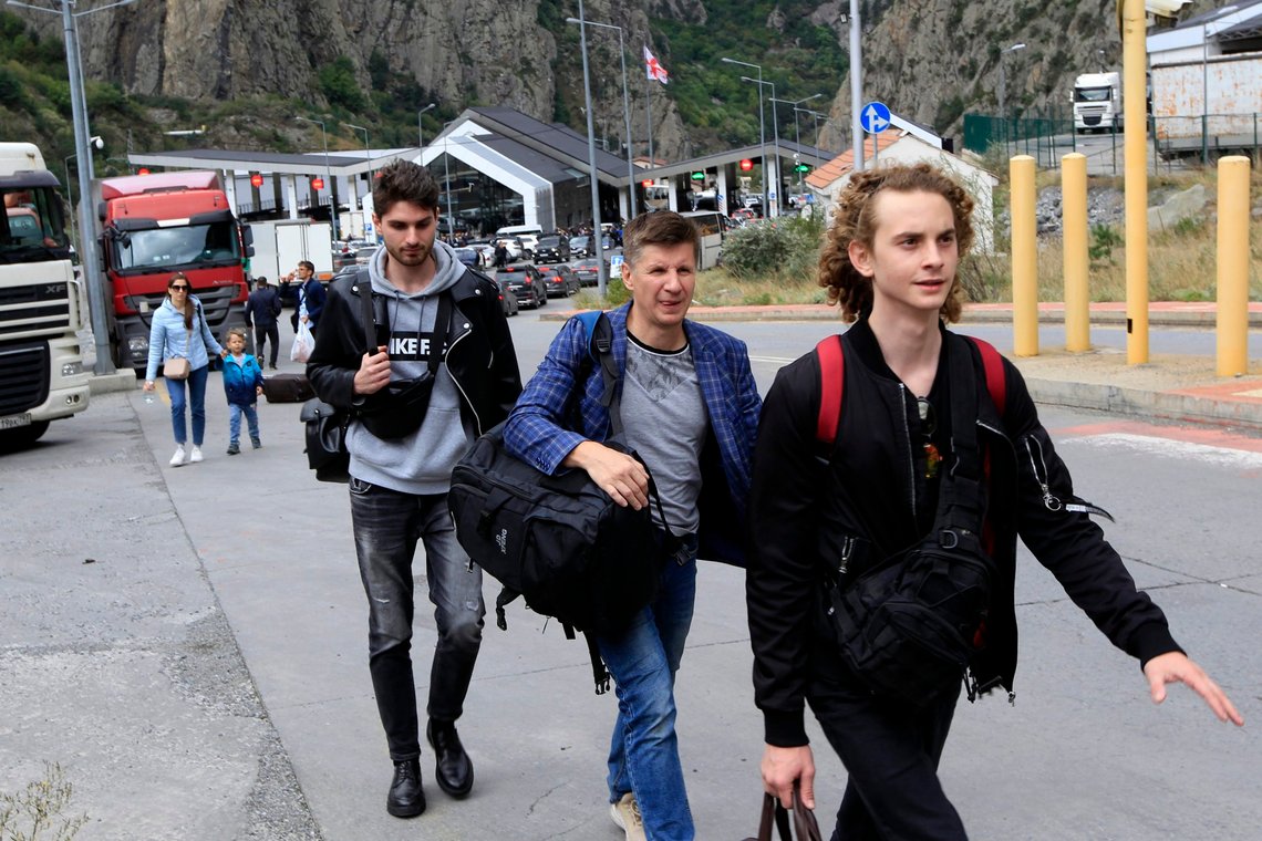 En gruppe unge russere går langs grenseovergangen Verkhny Lars mellom Georgia og Russland fredag 23. september 2022. Lange køer med kjøretøy har dannet seg ved en grenseovergang mellom Russlands Nord-Ossetia-region og Georgia etter at Moskva annonserte en delvis militær mobilisering. En dag etter at president Vladimir Putin beordret en delvis mobilisering for å styrke troppene sine i Ukraina, forlater mange russere hjemmene sine. (AP Photo/Shakh Aivazov) En gruppe unge russere går langs grenseovergangen Verkhny Lars mellom Georgia og Russland fredag 23. september 2022. Lange køer med kjøretøy har dannet seg ved en grenseovergang mellom Russlands Nord-Ossetia-region og Georgia etter at Moskva annonserte en delvis militær mobilisering. En dag etter at president Vladimir Putin beordret en delvis mobilisering for å styrke troppene sine i Ukraina, forlater mange russere hjemmene sine. (AP Photo/Shakh Aivazov)