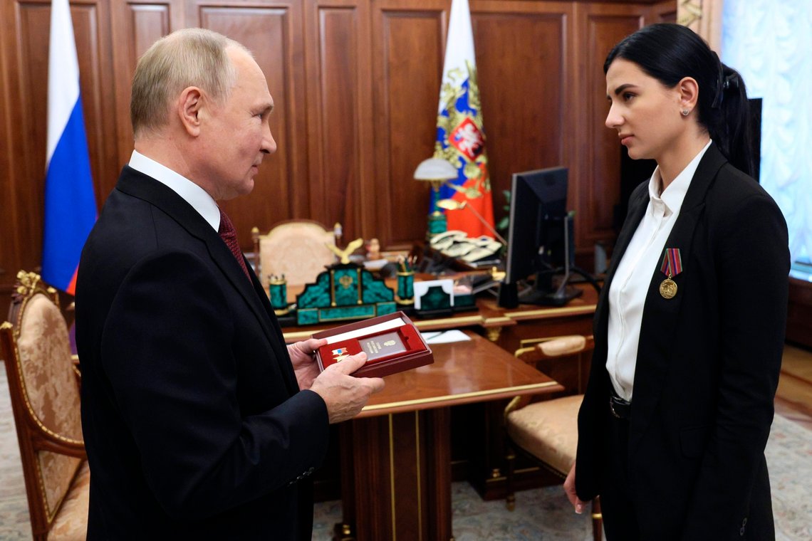 Russian President Vladimir Putin speaks to Elena Karabet, daughter of deceased commander of the rocket artillery division of the People's Militia of the Donetsk People's Republic Olga Kachura, as he gives an award for her mother at the Kremlin in Moscow, Russia, Wednesday, Oct. 12, 2022. Putin awarded Lt. Col. Olga Kachura, who was killed on July 29, 2022 after a Ukrainian missile hit her car, the posthumous Hero of Russia honour - the Russia's highest award. (Gavriil Grigorov, Sputnik, Kremlin Pool Photo via AP) Russian President Vladimir Putin speaks to Elena Karabet, daughter of deceased commander of the rocket artillery division of the People's Militia of the Donetsk People's Republic Olga Kachura, as he gives an award for her mother at the Kremlin in Moscow, Russia, Wednesday, Oct. 12, 2022. Putin awarded Lt. Col. Olga Kachura, who was killed on July 29, 2022 after a Ukrainian missile hit her car, the posthumous Hero of Russia honour - the Russia's highest award. (Gavriil Grigorov, Sputnik, Kremlin Pool Photo via AP)