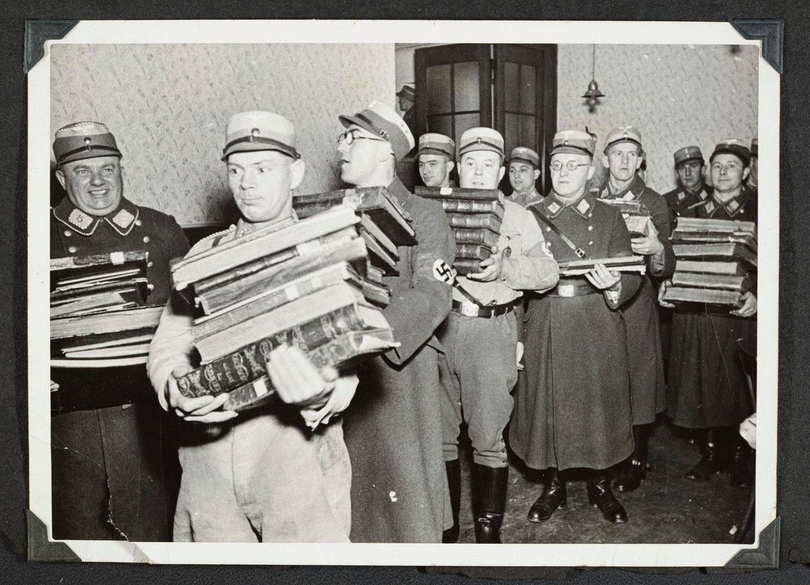 Tyske nazister bærer beslaglagte jødiske bøker som høyst sannsynlig skal brennes, trolig i Fürth i Bayern, under Krystallnatten den 10. november 1938. Foto: Yad Vashem Holocaust memorial via AP / NTB. Tyske nazister bærer beslaglagte jødiske bøker som høyst sannsynlig skal brennes, trolig i Fürth i Bayern, under Krystallnatten den 10. november 1938. Foto: Yad Vashem Holocaust memorial via AP / NTB.