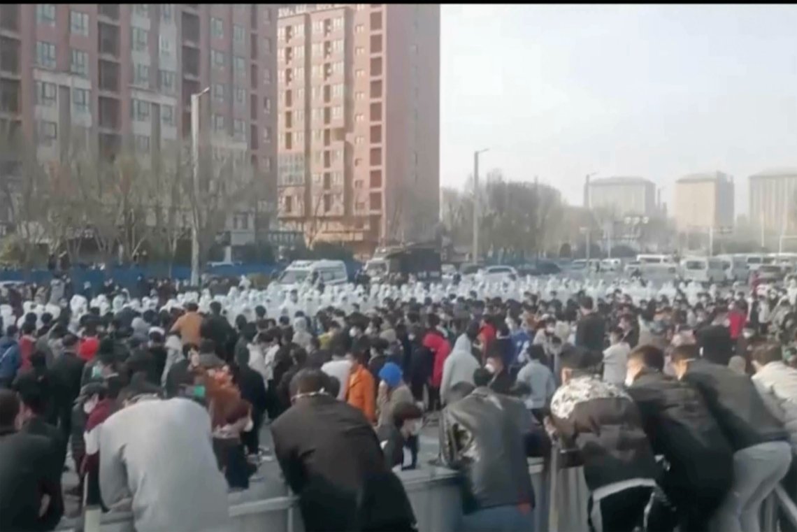 Store deler av den kinesiske byen Zhengzhou blir stengt ned, dagen etter store demonstrasjoner ved den enorme Iphone-fabrikken som ligger der. Dette bildet AP har fått tak i, viser demonstranter i sammenstøt med sikkerhetspersonell i hvitt. Foto: AP / NTB Store deler av den kinesiske byen Zhengzhou blir stengt ned, dagen etter store demonstrasjoner ved den enorme Iphone-fabrikken som ligger der. Dette bildet AP har fått tak i, viser demonstranter i sammenstøt med sikkerhetspersonell i hvitt. Foto: AP / NTB