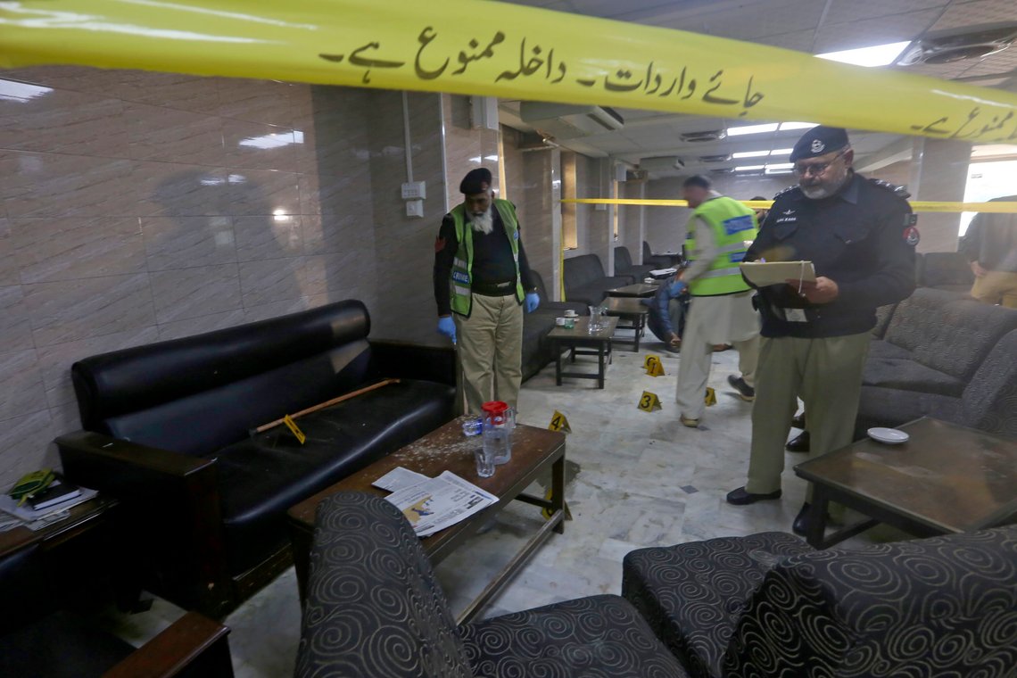 Police officers examine the crime scene following a shooting incident on the premises of the Peshawar High Court in Peshawar, Pakistan, Monday, Jan. 16, 2023. A man disguised as a lawyer shot and killed a prominent lawyer Abdul Latif Afridi on the court property in northwest Pakistan in an apparent case of an old enmity on Monday, police said. The attacker was quickly arrested. (AP Photo/Muhammad Sajjad) Police officers examine the crime scene following a shooting incident on the premises of the Peshawar High Court in Peshawar, Pakistan, Monday, Jan. 16, 2023. A man disguised as a lawyer shot and killed a prominent lawyer Abdul Latif Afridi on the court property in northwest Pakistan in an apparent case of an old enmity on Monday, police said. The attacker was quickly arrested. (AP Photo/Muhammad Sajjad)