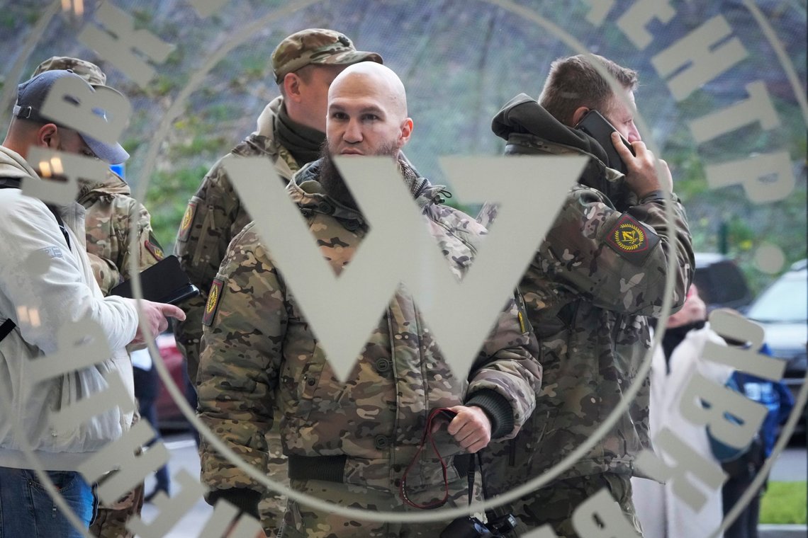 FILE - Visitors wearing military camouflage stand at the entrance of the 'PMC Wagner Centre', which is associated with businessman and founder of the Wagner private military group Yevgeny Prigozhin, during the official opening of the office block during National Unity Day, in St. Petersburg, Russia, Friday, Nov. 4, 2022. The 61-year-old Prigozhin, who has expanded his assets from catering business to Wagner and then mining and other spheres, has scathingly criticized the top military brass for their blunders in Ukraine, charging that Wagner was much more efficient than regular troops. (AP Photo, File) FILE - Visitors wearing military camouflage stand at the entrance of the 'PMC Wagner Centre', which is associated with businessman and founder of the Wagner private military group Yevgeny Prigozhin, during the official opening of the office block during National Unity Day, in St. Petersburg, Russia, Friday, Nov. 4, 2022. The 61-year-old Prigozhin, who has expanded his assets from catering business to Wagner and then mining and other spheres, has scathingly criticized the top military brass for their blunders in Ukraine, charging that Wagner was much more efficient than regular troops. (AP Photo, File)
