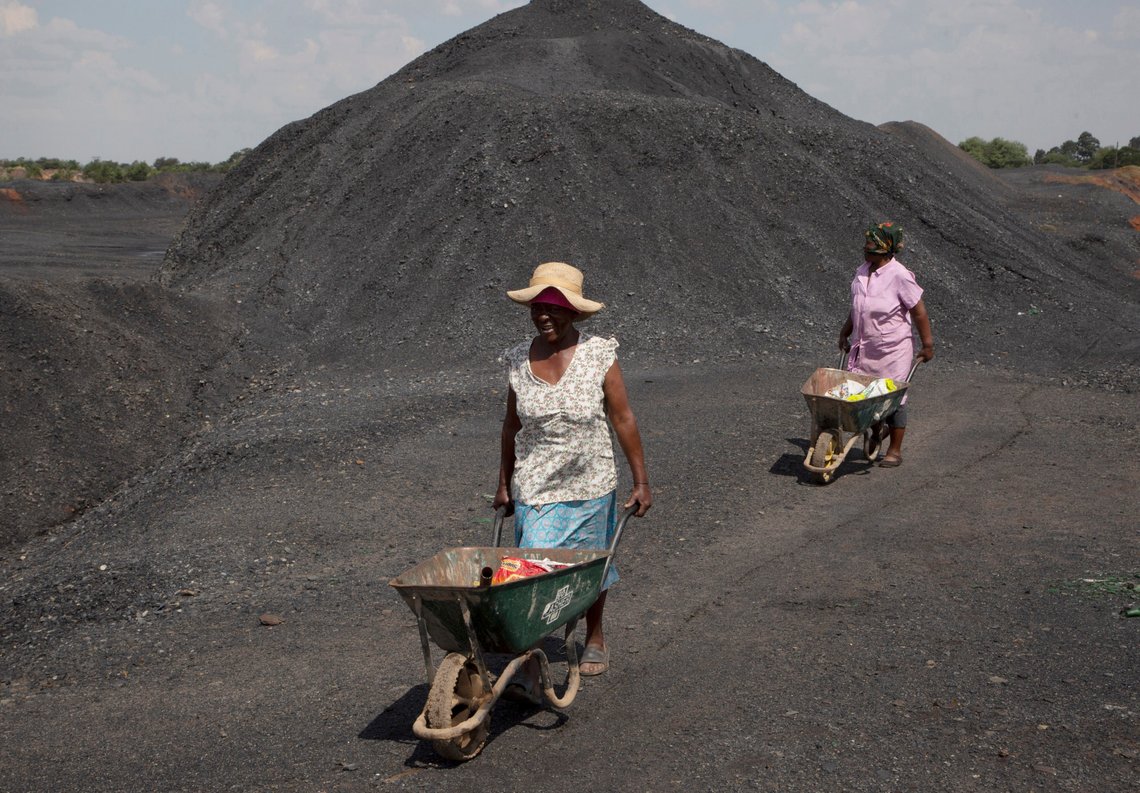 Arbeidsledige kvinner med trillebår over en kullgruve ved Masakhane Township. Foto: AP /Denis Farrell/ NTB Arbeidsledige kvinner med trillebår over en kullgruve ved Masakhane Township. Foto: AP /Denis Farrell/ NTB