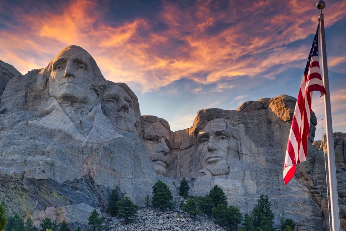 Keystone, South Dakota / USA – August 2, 2016: An American flag waves in front of Mount Rushmore National Memorial. Photo: Shutterstock, Bill Chizek, USA. (Det er plass til Joe Biden til høyre, ved siden av Abraham Lincoln. journ. anm.) Keystone, South Dakota / USA – August 2, 2016: An American flag waves in front of Mount Rushmore National Memorial. Photo: Shutterstock, Bill Chizek, USA. (Det er plass til Joe Biden til høyre, ved siden av Abraham Lincoln. journ. anm.)