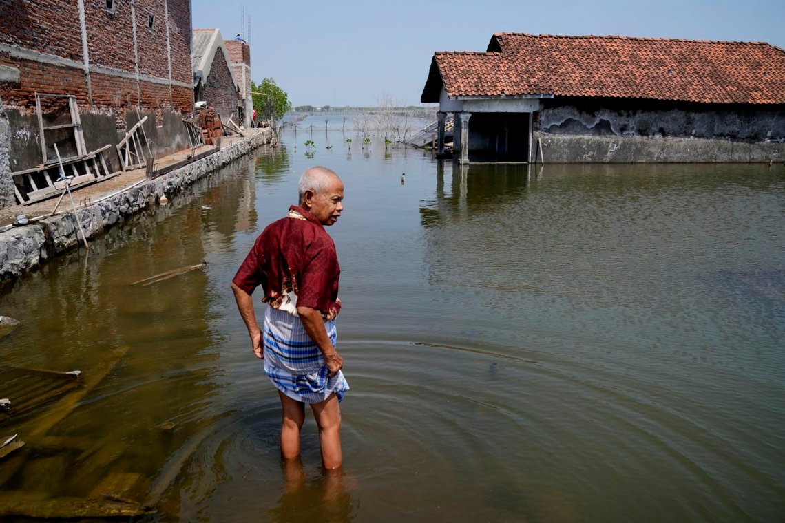 En mann går på en oversvømt sti utenfor huset sitt i Timbulsloko, i det sentral Java, Indonesia, 30. juli, 2022. FNs Generalsekretær Antonio Guterres tror at dette har med global oppvarming og et stigende havnivå å gjøre. Foto: AP/Dita Alangkara En mann går på en oversvømt sti utenfor huset sitt i Timbulsloko, i det sentral Java, Indonesia, 30. juli, 2022. FNs Generalsekretær Antonio Guterres tror at dette har med global oppvarming og et stigende havnivå å gjøre. Foto: AP/Dita Alangkara