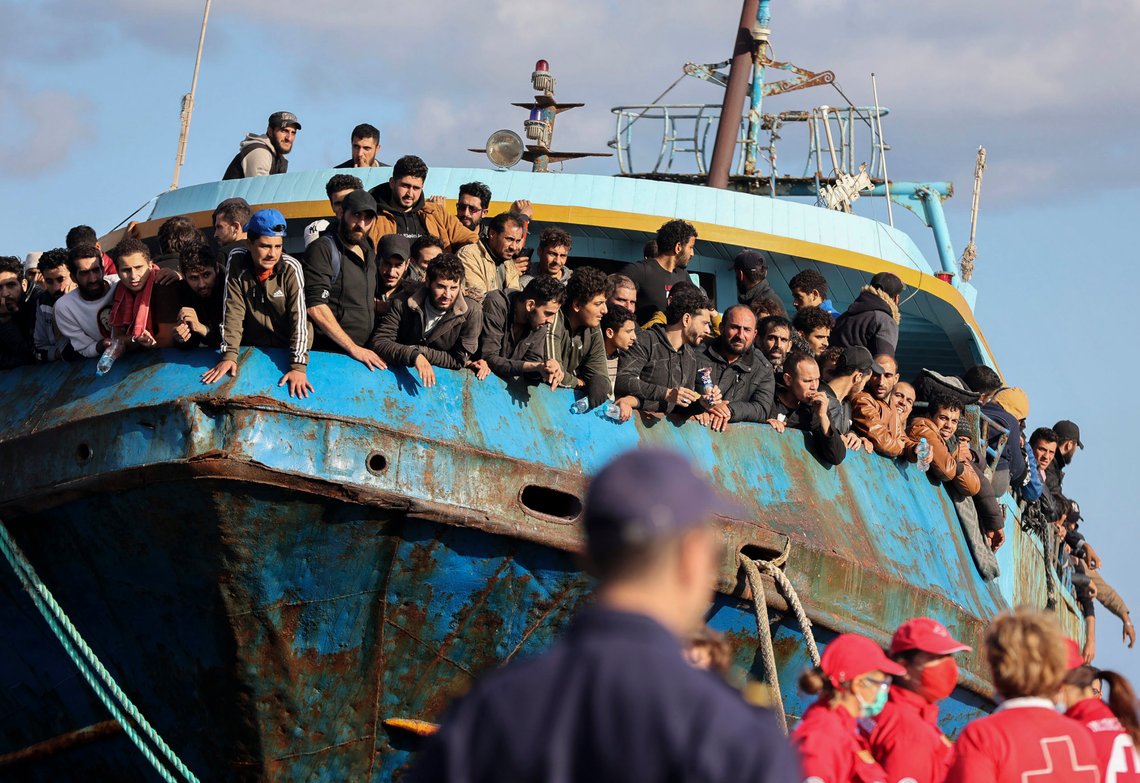 Migrants look out of a fishing boat docked at the port of Palaiochora in southeastern Crete, Greece, after its arrival, on Tuesday, Nov. 22, 2022 . Greek authorities say a fishing boat crammed with hundreds of migrants that lost steering and had been drifting in the Mediterranean south of the Greek island of Crete has been successfully towed to port. There were no immediate reports of any injuries or missing people. (InTime News via AP) Migrants look out of a fishing boat docked at the port of Palaiochora in southeastern Crete, Greece, after its arrival, on Tuesday, Nov. 22, 2022 . Greek authorities say a fishing boat crammed with hundreds of migrants that lost steering and had been drifting in the Mediterranean south of the Greek island of Crete has been successfully towed to port. There were no immediate reports of any injuries or missing people. (InTime News via AP)