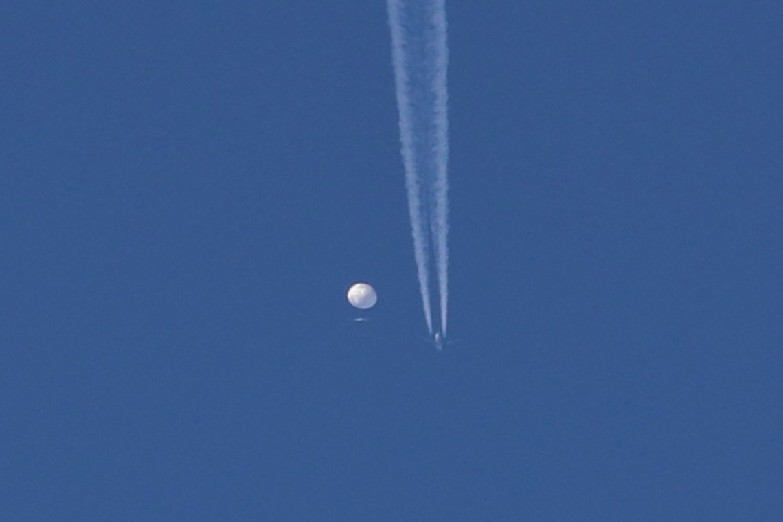 In this photo provided by Brian Branch, a large balloon drifts above the Kingston, N.C. area, with an airplane and its contrail seen below it. The United States says it is a Chinese spy balloon moving east over America at an altitude of about 60,000 feet (18,600 meters), but China insists the balloon is just an errant civilian airship used mainly for meteorological research that went off course due to winds and has only limited “self-steering” capabilities. (Brian Branch via AP) In this photo provided by Brian Branch, a large balloon drifts above the Kingston, N.C. area, with an airplane and its contrail seen below it. The United States says it is a Chinese spy balloon moving east over America at an altitude of about 60,000 feet (18,600 meters), but China insists the balloon is just an errant civilian airship used mainly for meteorological research that went off course due to winds and has only limited “self-steering” capabilities. (Brian Branch via AP)