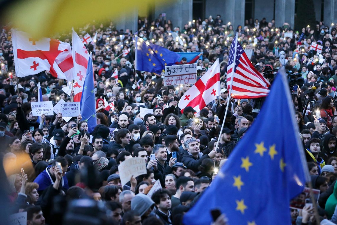 Protesters gather with American, Georgian, Ukrainian national and EU flags outside the Georgian parliament building in Tbilisi, Georgia, Wednesday, March 8, 2023. Thousands of people have been massing for days in Tbilisi to protest against a controversial planned law aimed at curbing the influence of "foreign agents", among fears it could be used to silence oppositions. (AP Photo/Zurab Tsertsvadze) Protesters gather with American, Georgian, Ukrainian national and EU flags outside the Georgian parliament building in Tbilisi, Georgia, Wednesday, March 8, 2023. Thousands of people have been massing for days in Tbilisi to protest against a controversial planned law aimed at curbing the influence of "foreign agents", among fears it could be used to silence oppositions. (AP Photo/Zurab Tsertsvadze)